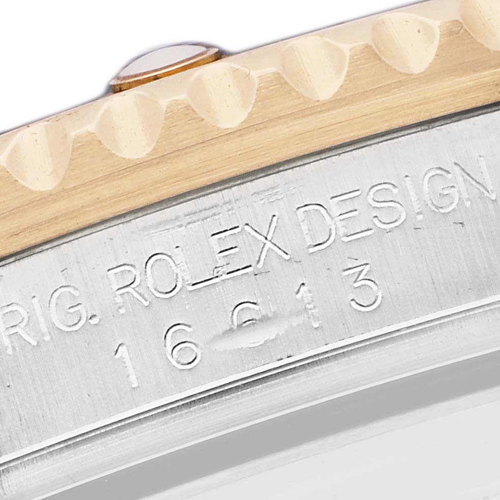 The image shows a close-up of the case edge and part of the bezel of a Rolex Submariner, model number 16613, with engraving visible.