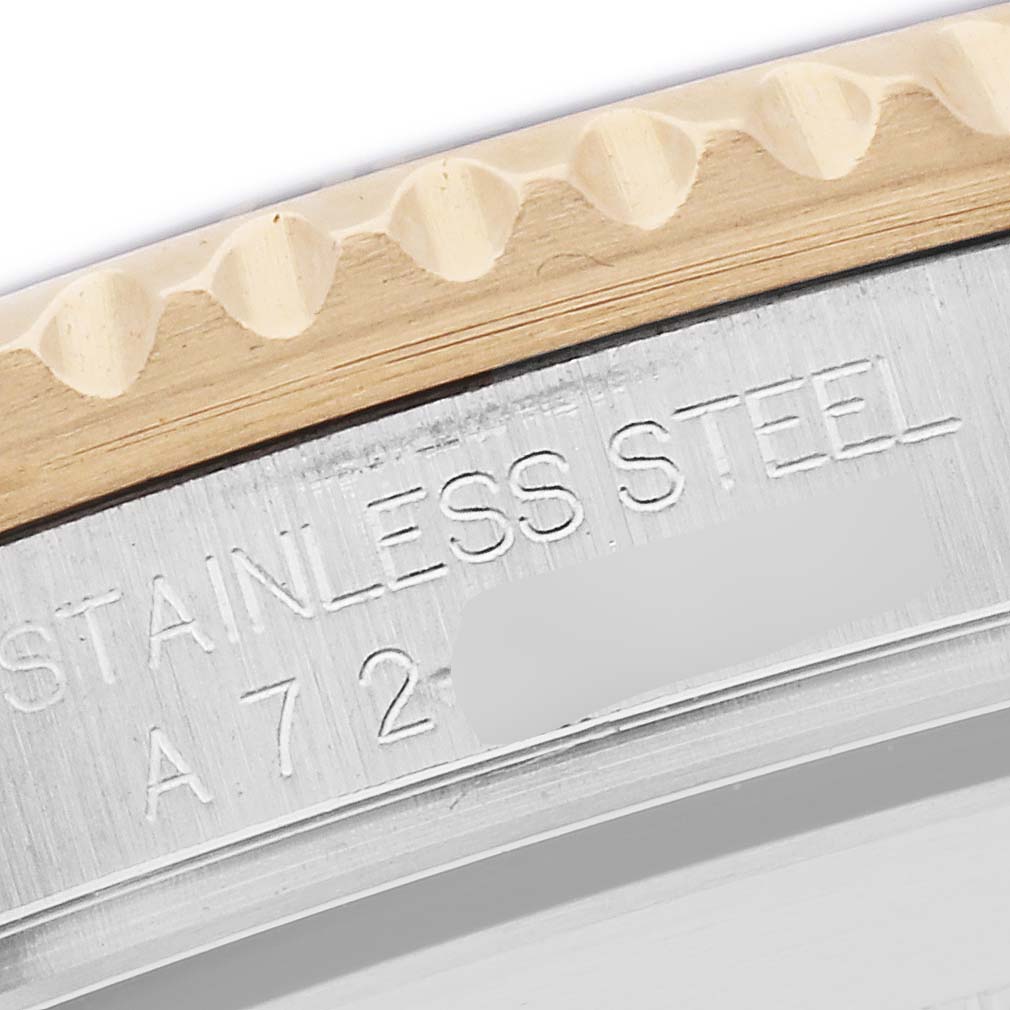 The image shows a close-up of the bezel and the engraved stainless steel side of a Rolex Submariner, model number 16613, highlighting the metal texture and details.