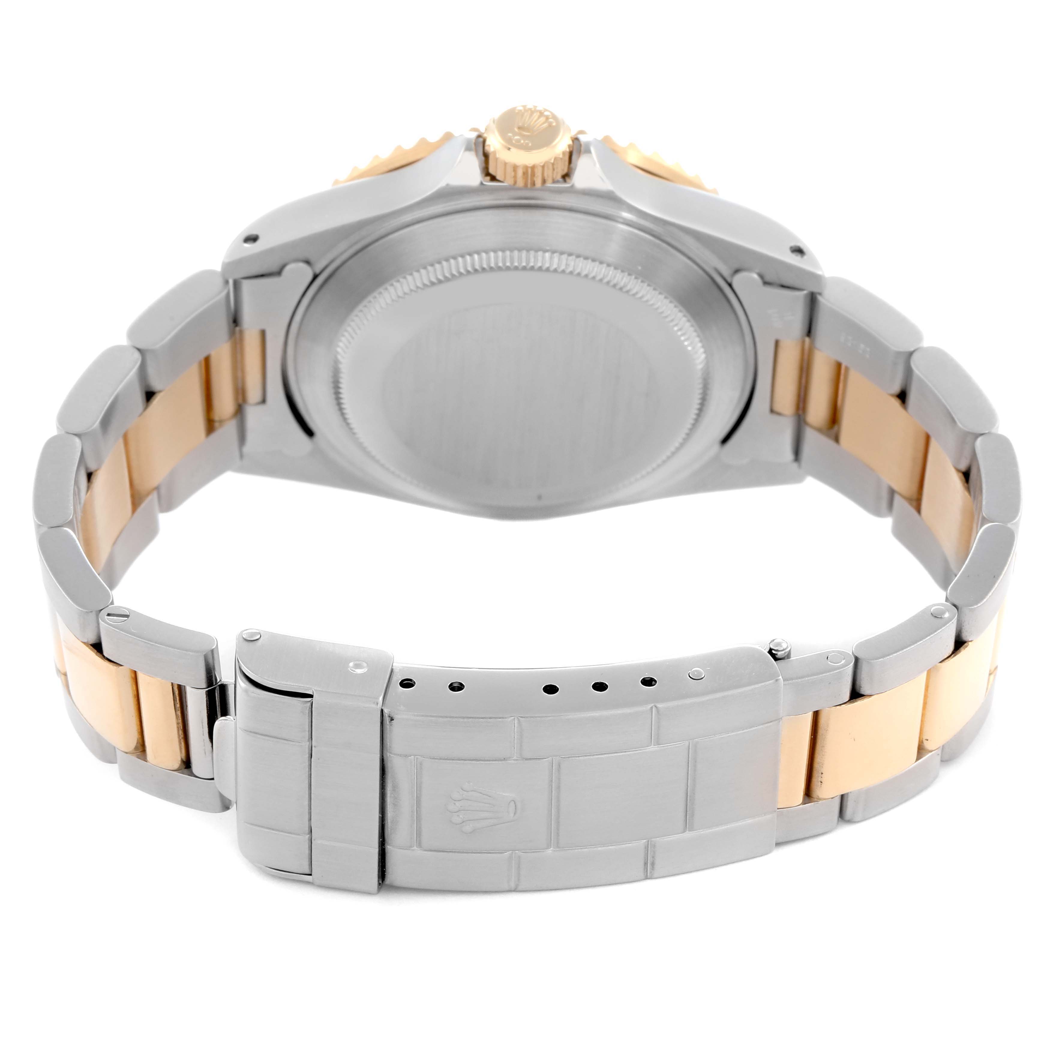 The image shows the back view of a Rolex Submariner model 16613 men's watch, highlighting the case back and stainless steel and gold bracelet clasp.