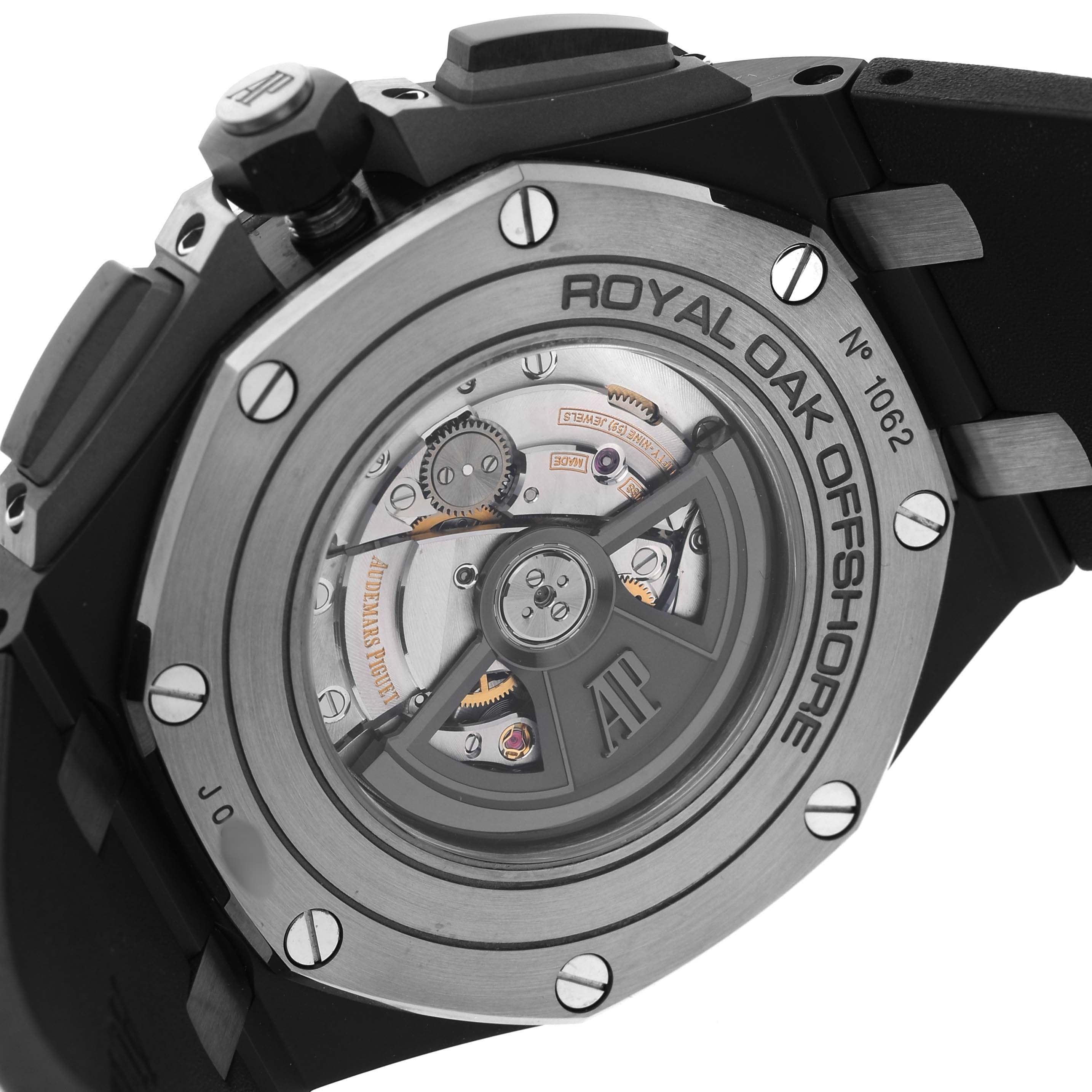 The image shows the back of an Audemars Piguet Royal Oak Offshore 26405CE.OO.A002CA.01 Men's Ceramic Grey Dial watch, highlighting its exposed movement and case details.