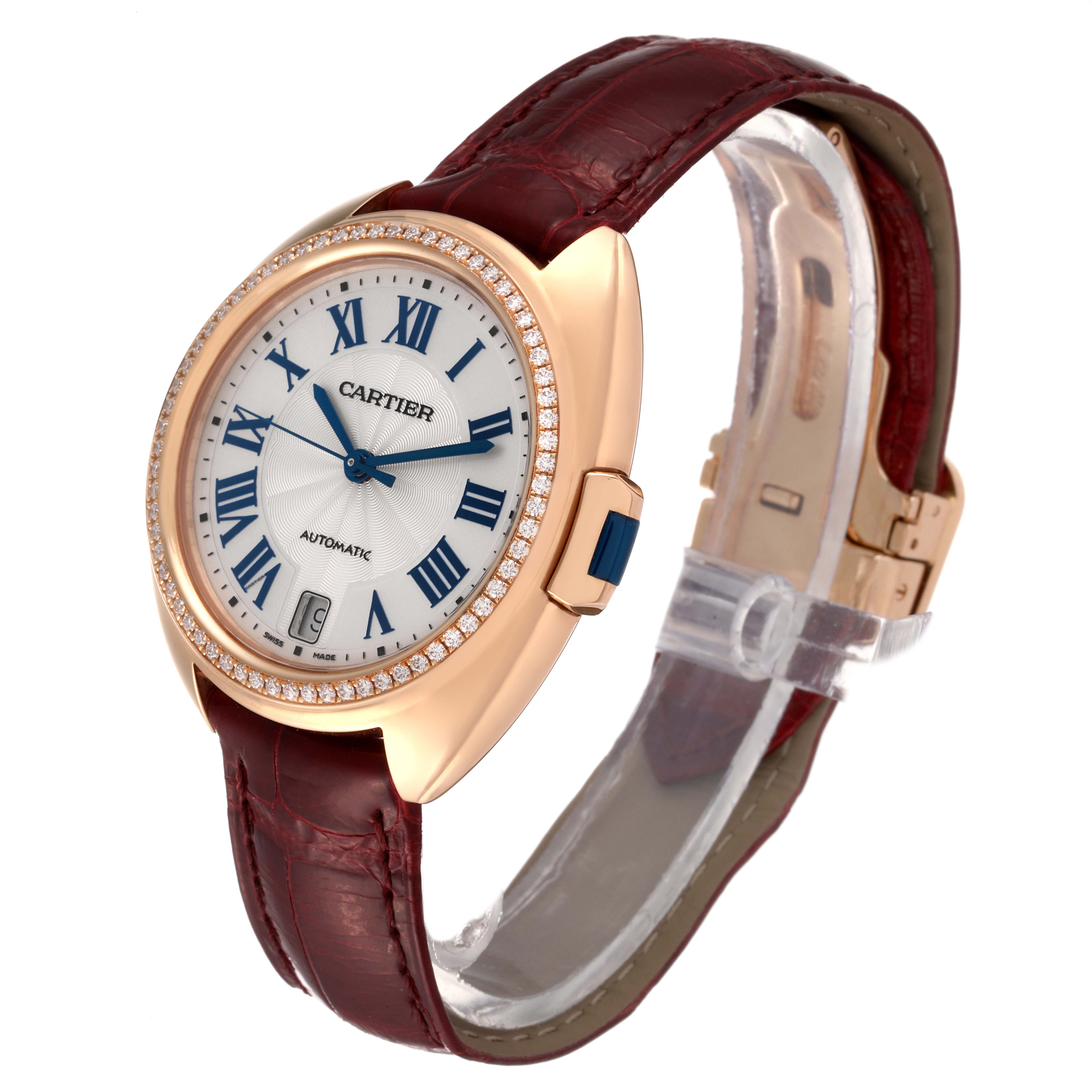 The Cartier Clé watch is shown at an angle revealing the dial, crown, and leather strap.