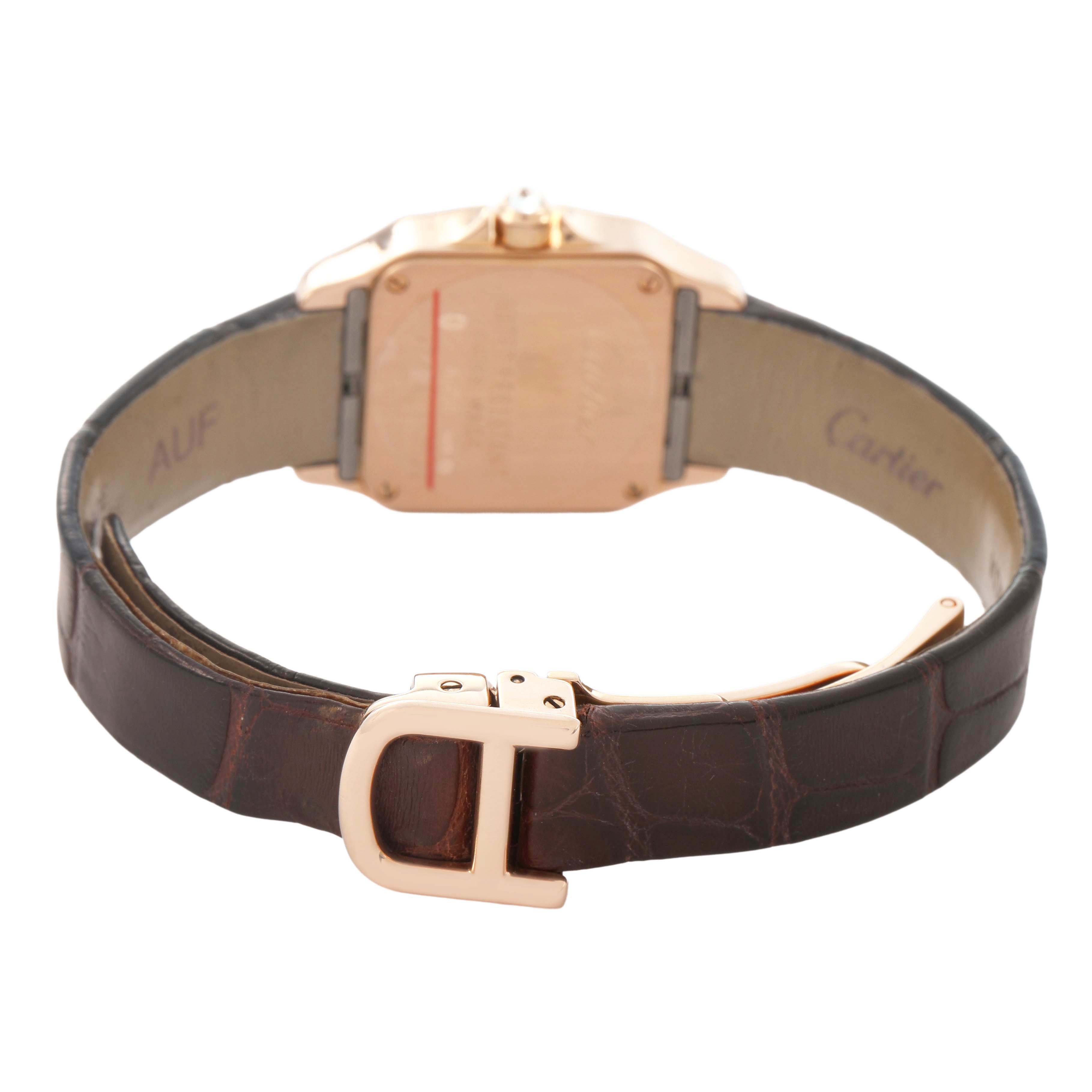 The image shows the Santos Demoiselle model by Cartier from the back, highlighting the case back and leather strap clasp.