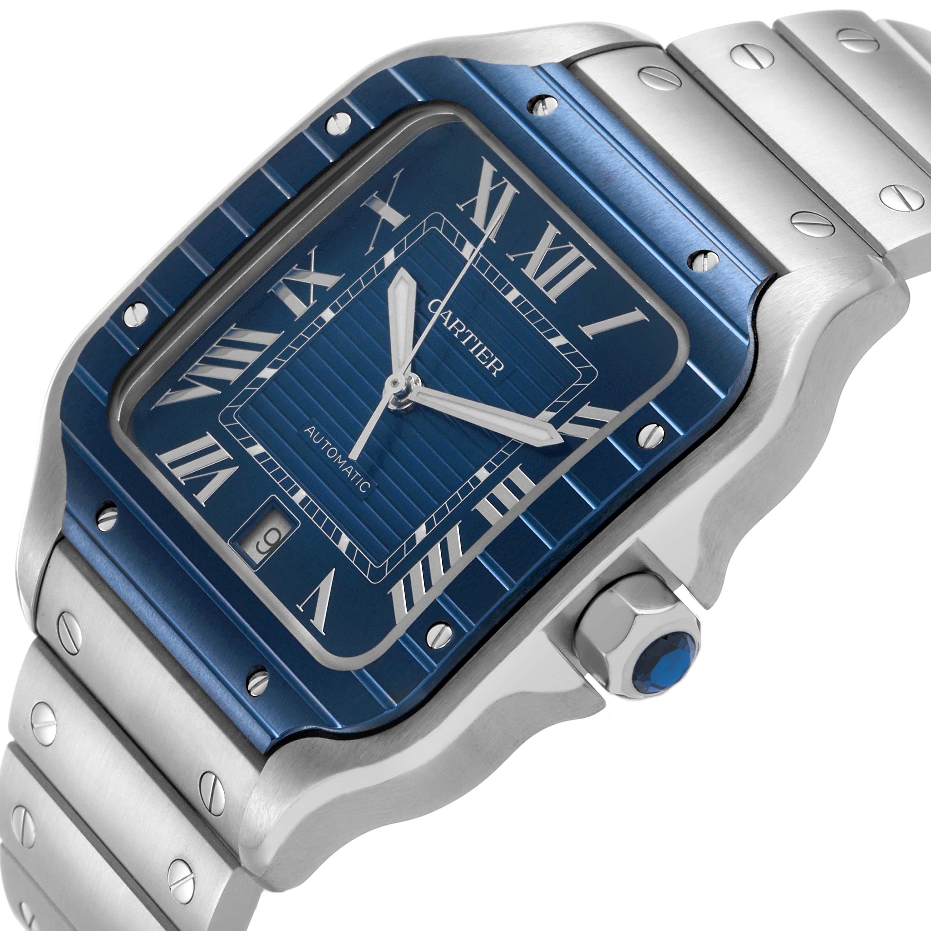 The Cartier Santos WSSA0048 Men's Stainless Steel Blue Dial watch is shown at an angled view, highlighting the blue dial, bezel, and part of the bracelet.