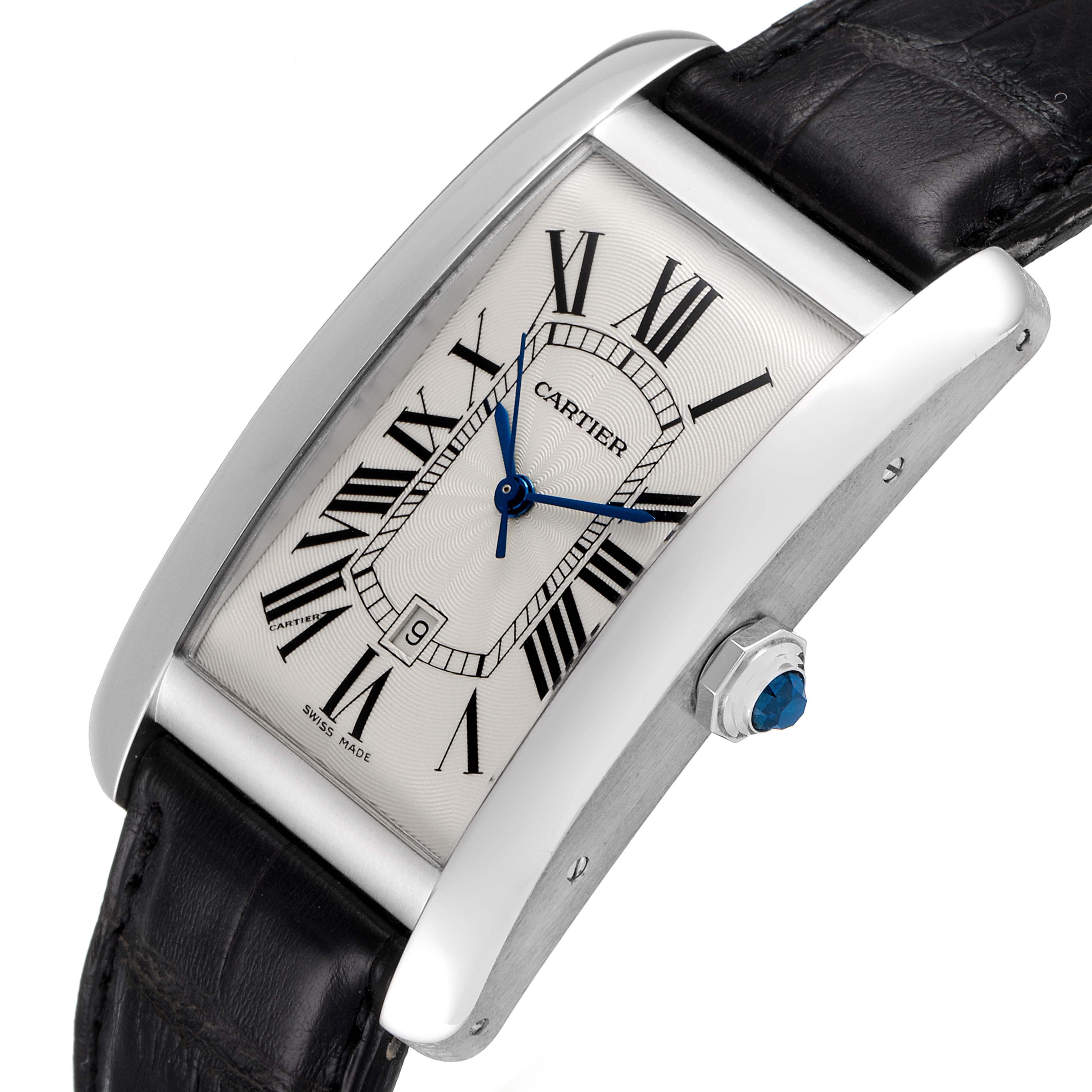 The image shows a Cartier Tank Americaine W2603256 Men
s Stainless Steel Silver Dial W2603256 Men
s Stainless Steel Silver Dial watch at an angled view, highlighting its face, Roman numerals, and side crown.