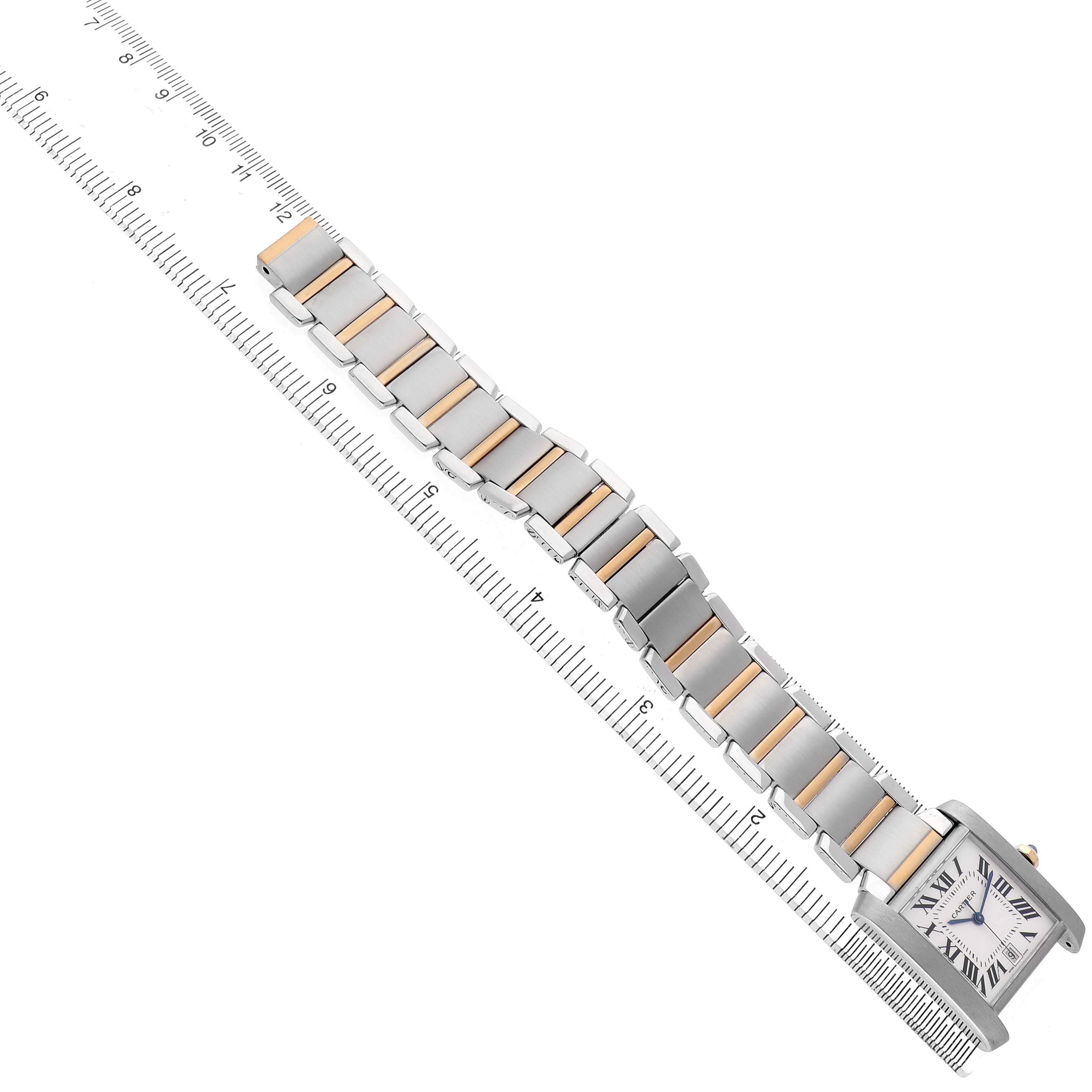 The Cartier Tank Francaise W51005Q4 Men's Stainless Steel Silver Dial watch is shown from a top angle, displaying its face and entire bracelet alongside a ruler.