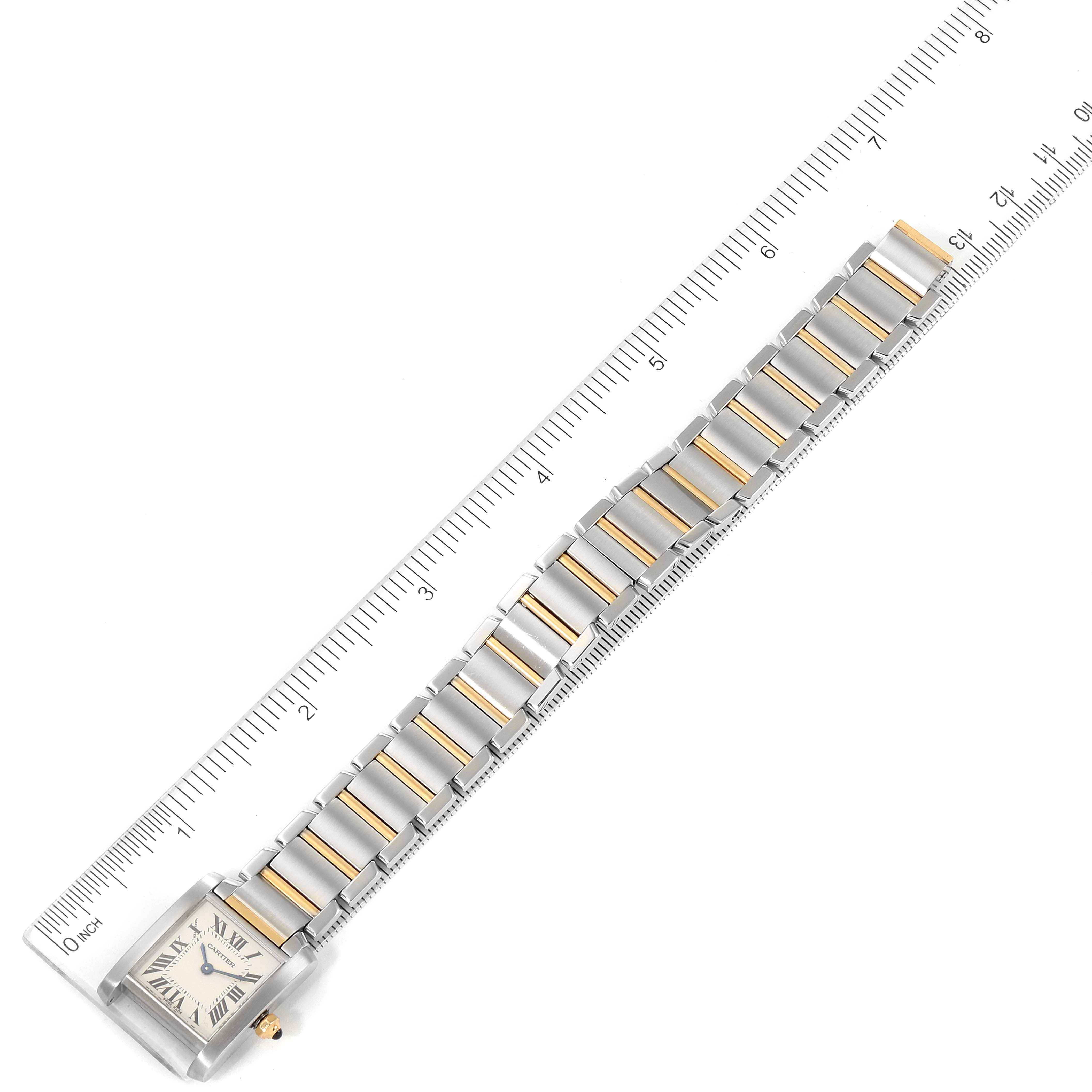 The image shows a Cartier Tank Française watch laid flat next to a ruler, displaying the entire bracelet and rectangular face.