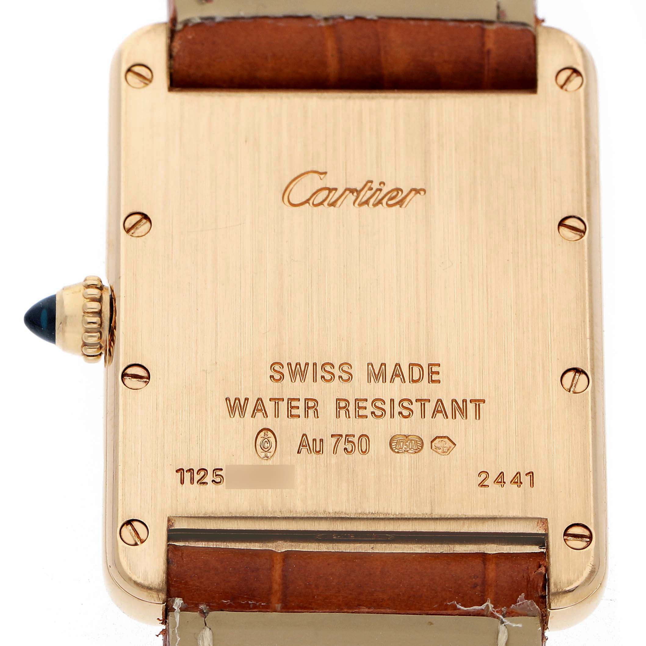 The image shows the back case of a Cartier Tank Louis W1529756 Men's Yellow Gold Silver Dial watch with engravings and a partially visible strap.