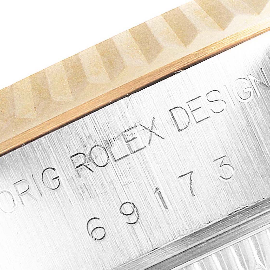 This is a close-up image of the side of a Rolex Datejust 69173 Women's Steel and Gold (two tone) Champagne Dial 69173 Women's Steel and Gold (two tone) Champagne Dial watch showing the engraved model number and part of the bezel.
