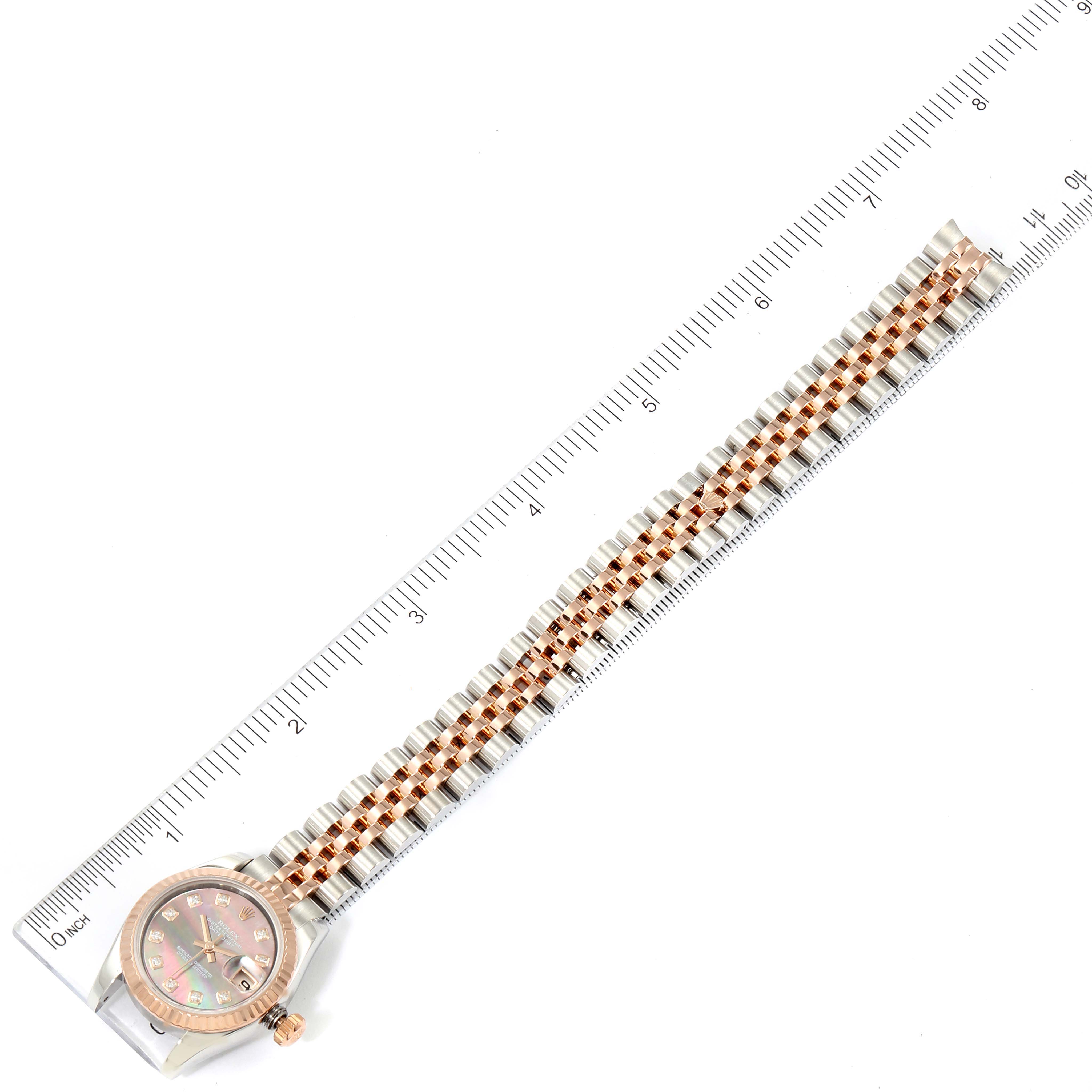 The image shows a Rolex Datejust 179171 Women's Steel and Gold (two tone) Mother of Pearl Dial 179171 Women's Steel and Gold (two tone) Mother of Pearl Dial watch lying flat next to a ruler, displaying both the dial and the full length of the bracelet.