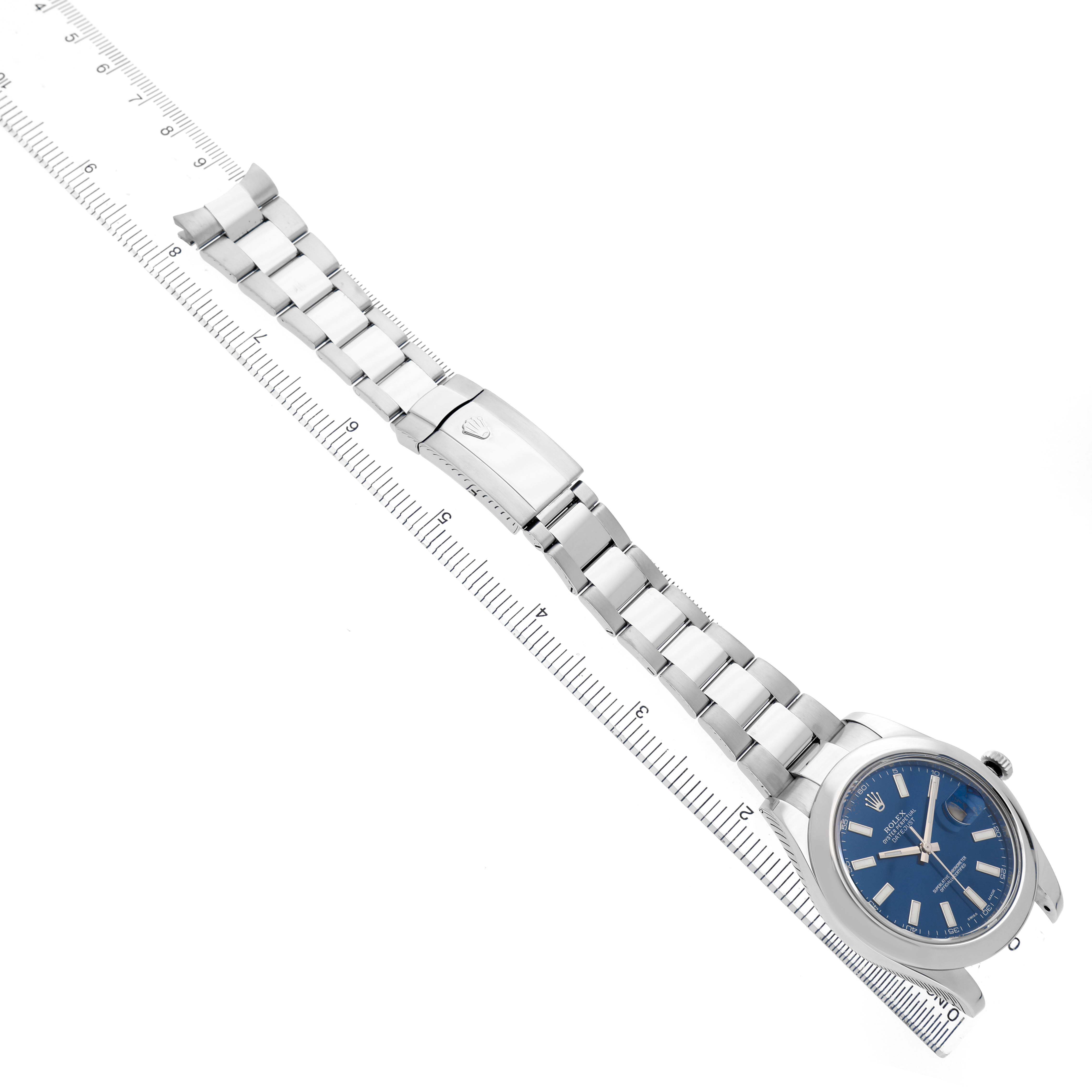 The Rolex Datejust 41 116300 Men's Stainless Steel Blue Dial watch is shown at an overhead angle, displaying the bracelet, clasp, bezel, and blue dial next to a ruler.