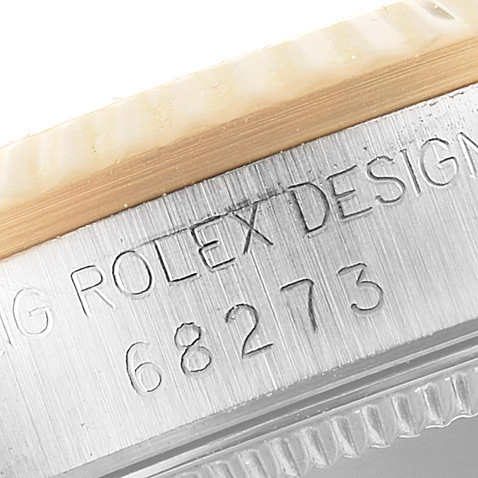 The image shows a close-up of the side case and bezel of a Rolex Mid-Size 68273 Women's Steel and Gold (two tone) Champagne Dial 68273 Women's Steel and Gold (two tone) Champagne Dial model, showcasing the engraved design and model number 68273.