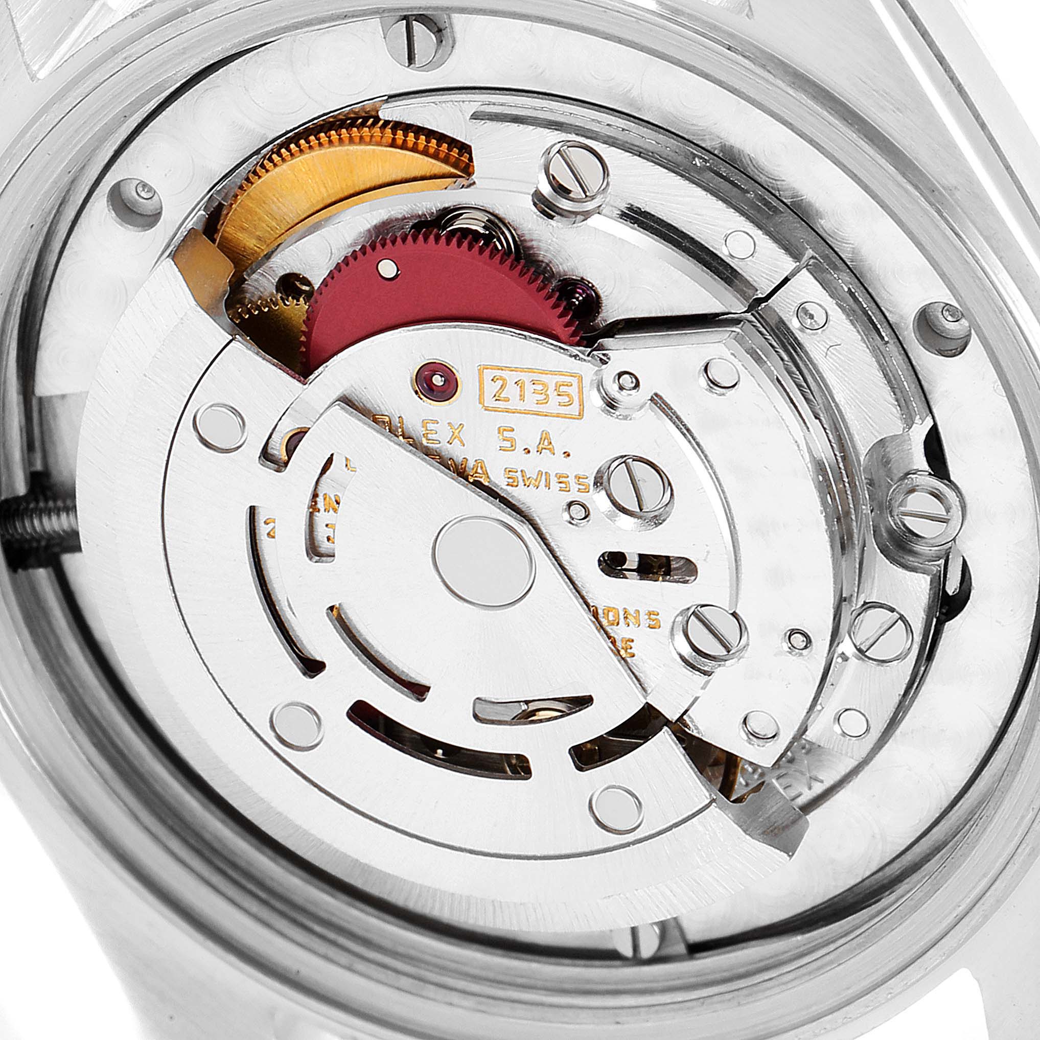 The image shows the internal mechanism of a Mid-Size Rolex watch, viewed from the back, highlighting components like gears and the balance wheel.