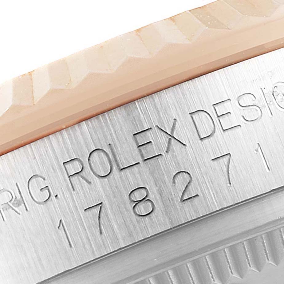 The image shows a close-up angle of the engraved serial number and name on the bezel of a Mid-Size Rolex watch.