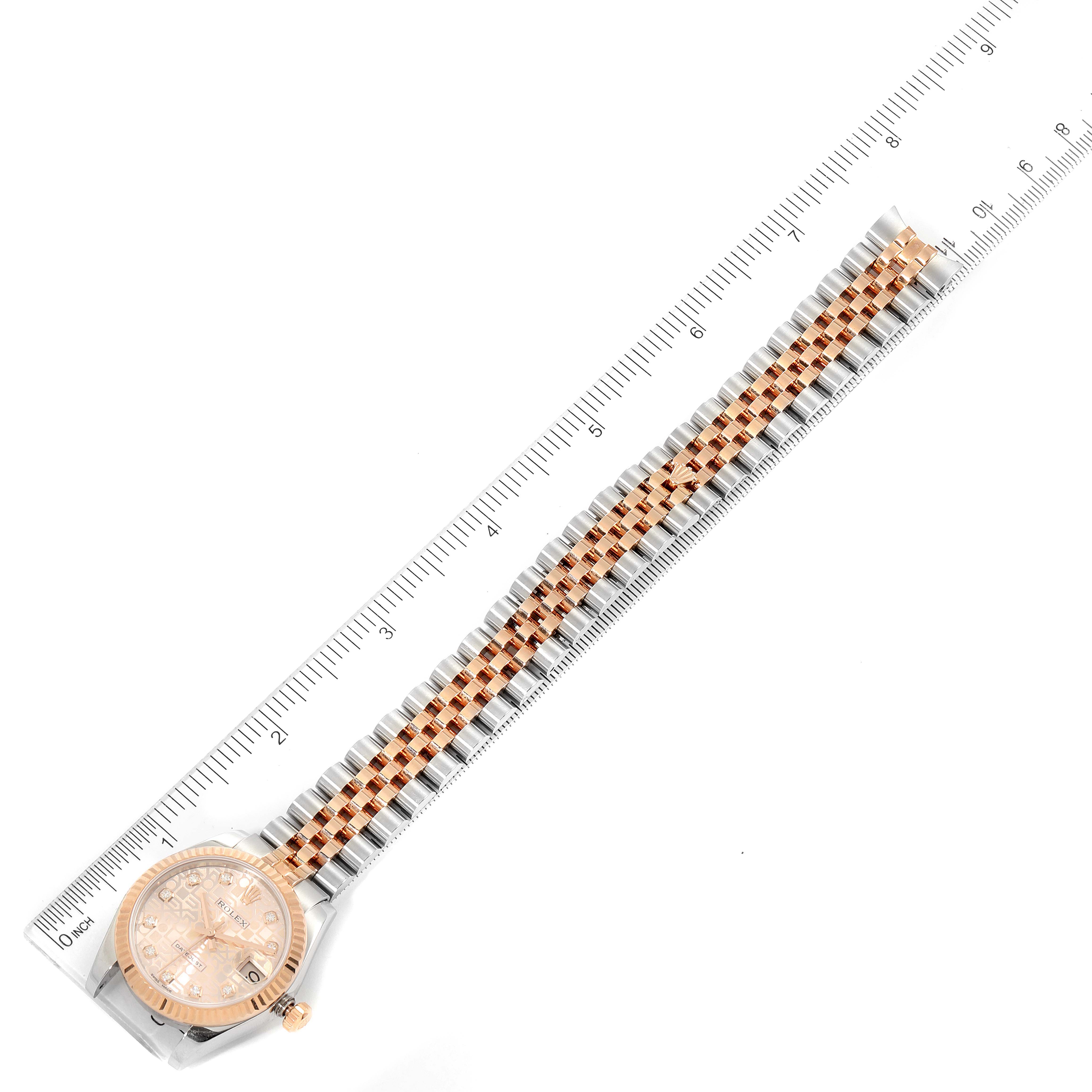 This image shows the Rolex Mid-Size 178271 Women's Steel and Gold (two tone) Pink Dial 178271 Women's Steel and Gold (two tone) Pink Dial watch at a top-down angle, showcasing the face, bezel, and bracelet alongside a ruler for scale.