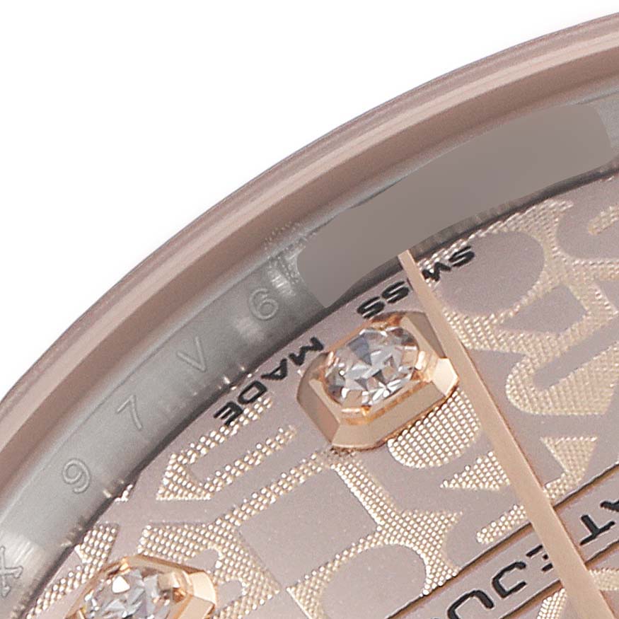 This close-up shows part of the dial, bezel, and diamond markers of a Mid-Size Rolex watch.