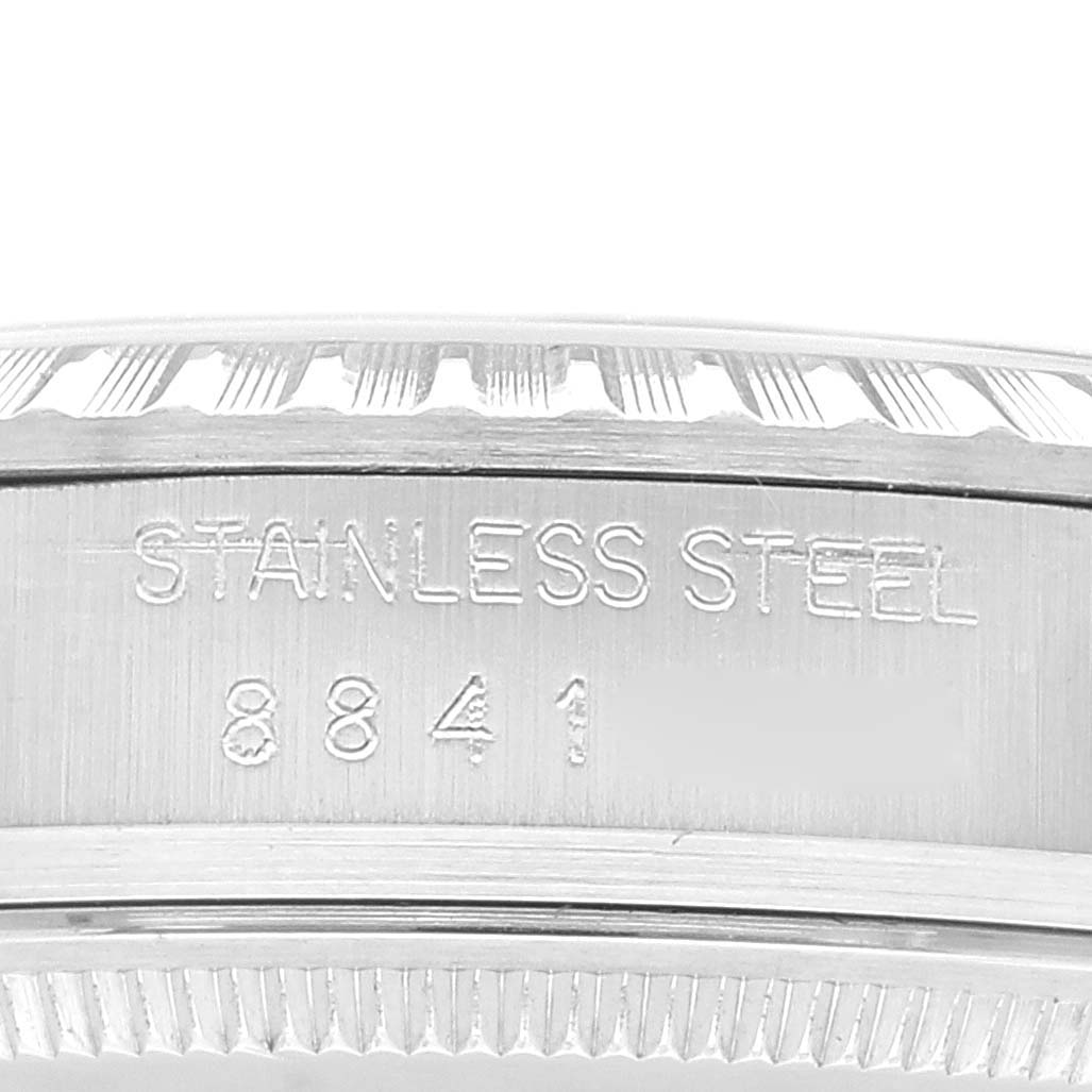 This image shows a close-up of the side of the case of a Rolex Vintage Collection 16030 Men's Stainless Steel Silver Dial 16030 Men's Stainless Steel Silver Dial watch, highlighting the "STAINLESS STEEL" engraving and model number.