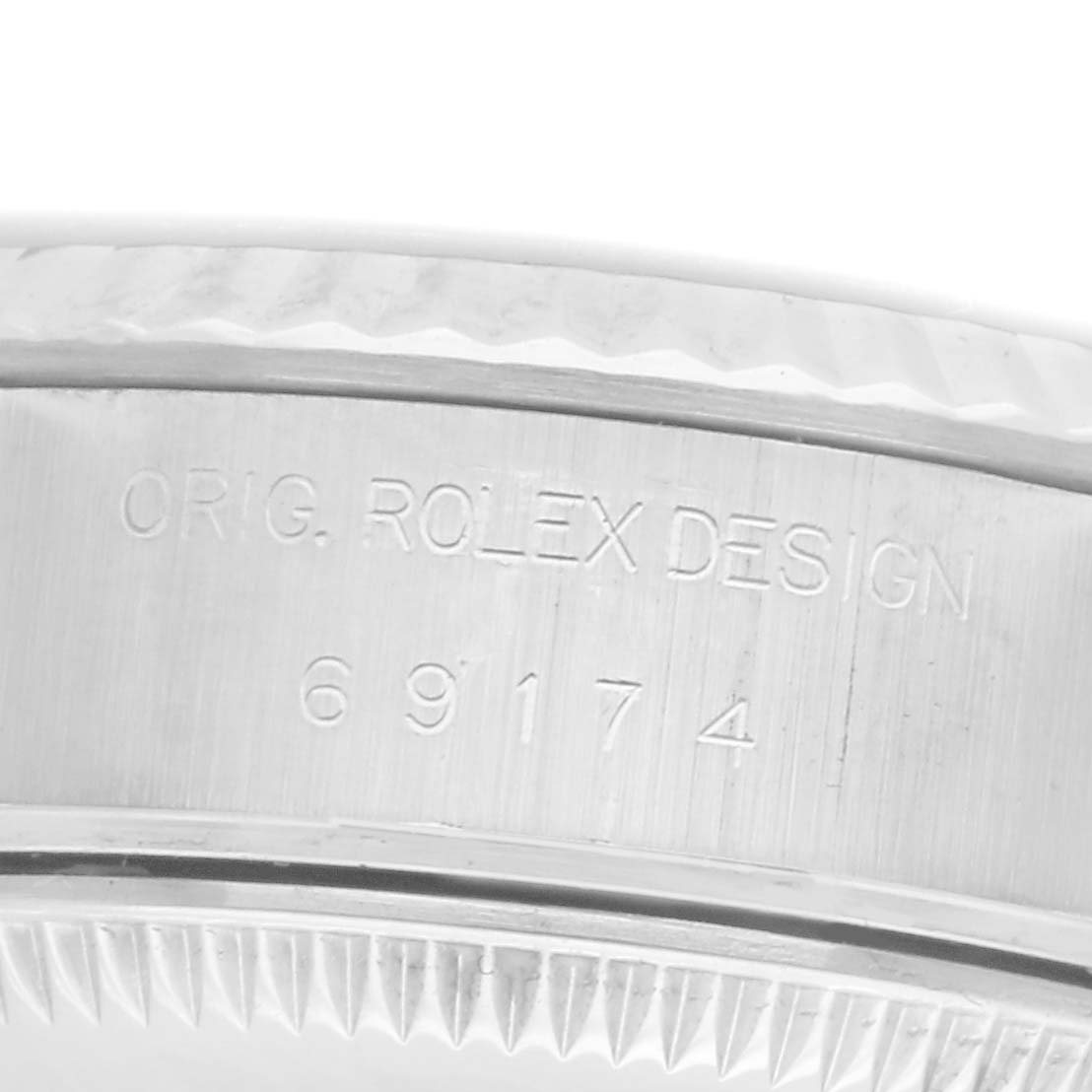 The image shows a close-up side view of the casing of a Rolex Datejust watch, model number 69174, displaying "ORIG. ROLEX DESIGN" and the model number engraving.