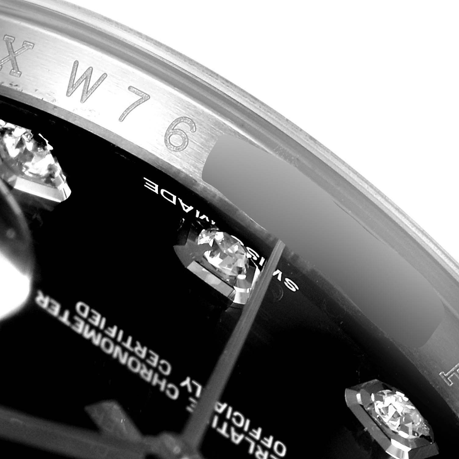 This close-up image of a Rolex Datejust 116234 Men's Stainless Steel Black Dial 116234 Men's Stainless Steel Black Dial watch shows part of the dial with diamond hour markers and part of the rehaut with engravings.