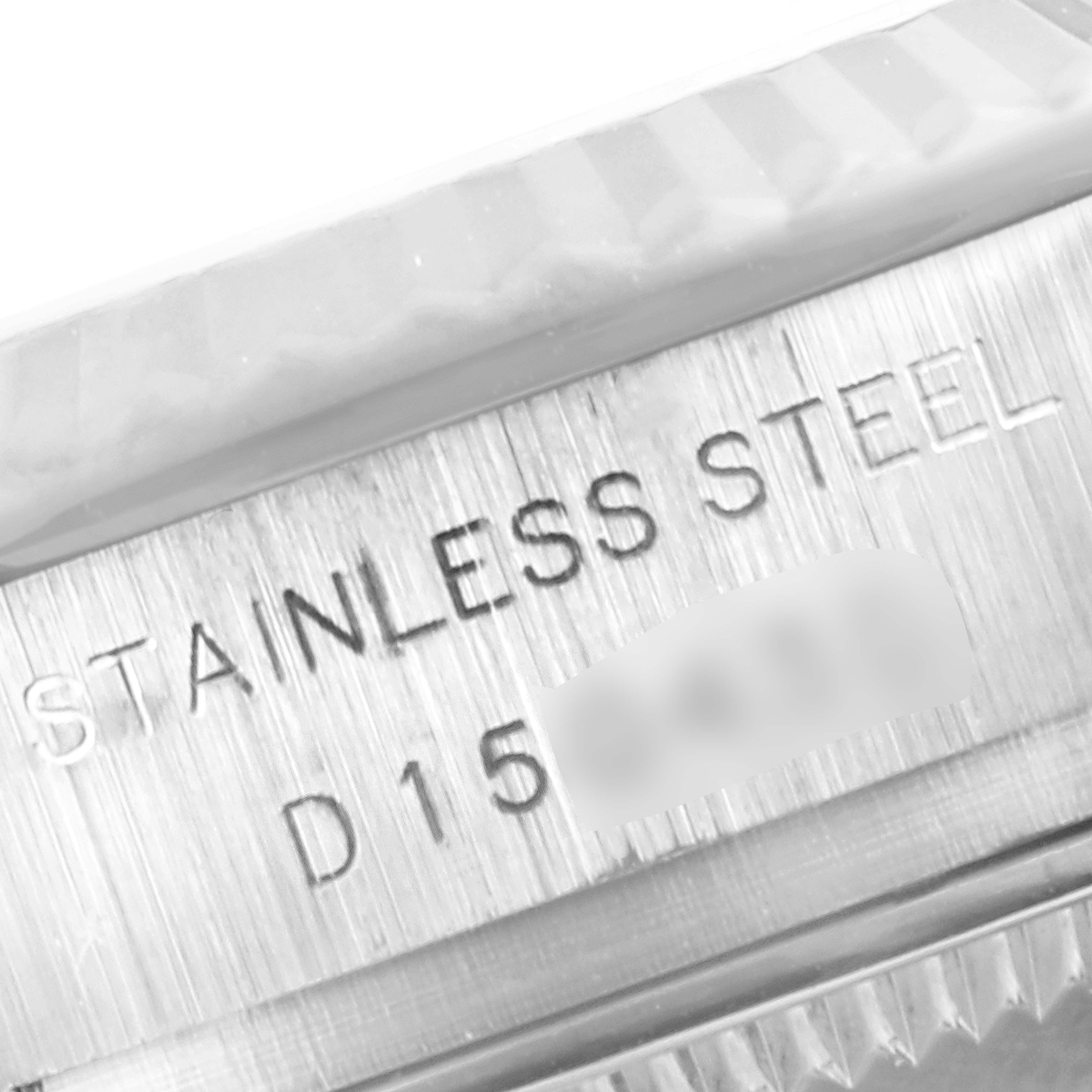 The image shows a close-up of the engravings on the case of a Rolex Datejust 179174 Women's Stainless Steel Pink Dial 179174 Women's Stainless Steel Pink Dial watch, indicating "STAINLESS STEEL" and part of the serial number.
