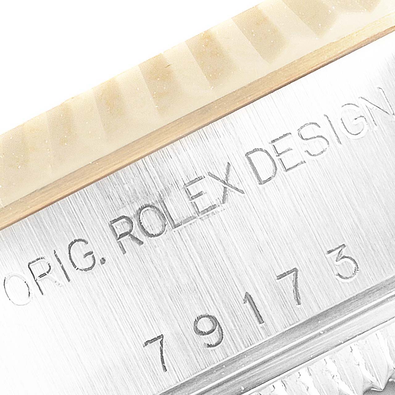 Close-up of the side engraving and bezel of the Rolex Datejust 79173 Women
s Steel and Gold (two tone) Silver Dial 79173 Women
s Steel and Gold (two tone) Silver Dial watch, showing "ORIG. ROLEX DESIGN" and model number.
