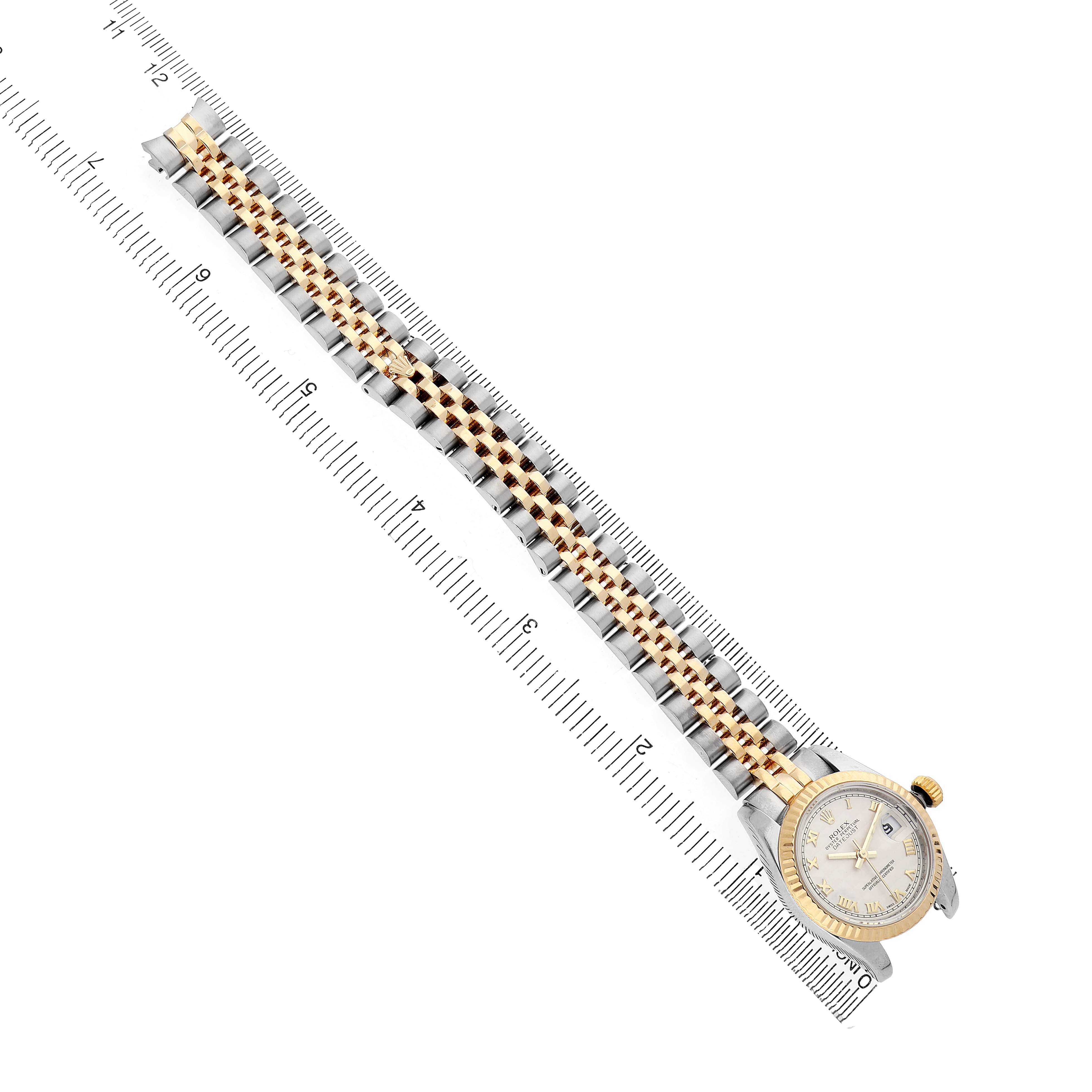 The Rolex Datejust 179173 Women's Steel and Gold (two tone) White Dial watch is shown from a top-down angle, highlighting the band and face alongside a ruler for size reference.