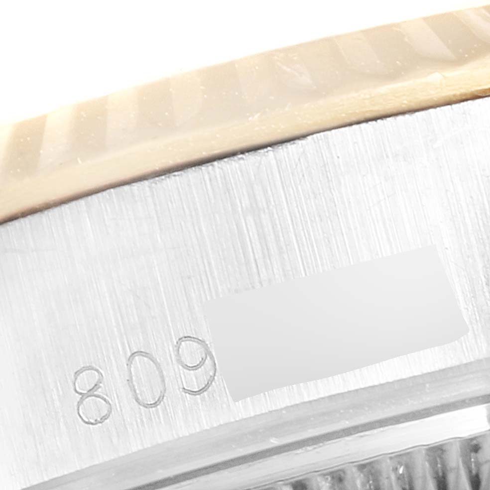 This close-up image shows the serial number engraving on the side of a Rolex Datejust 69173 Women
s Steel and Gold (two tone) Champagne Dial 69173 Women
s Steel and Gold (two tone) Champagne Dial watch case and part of its bezel.