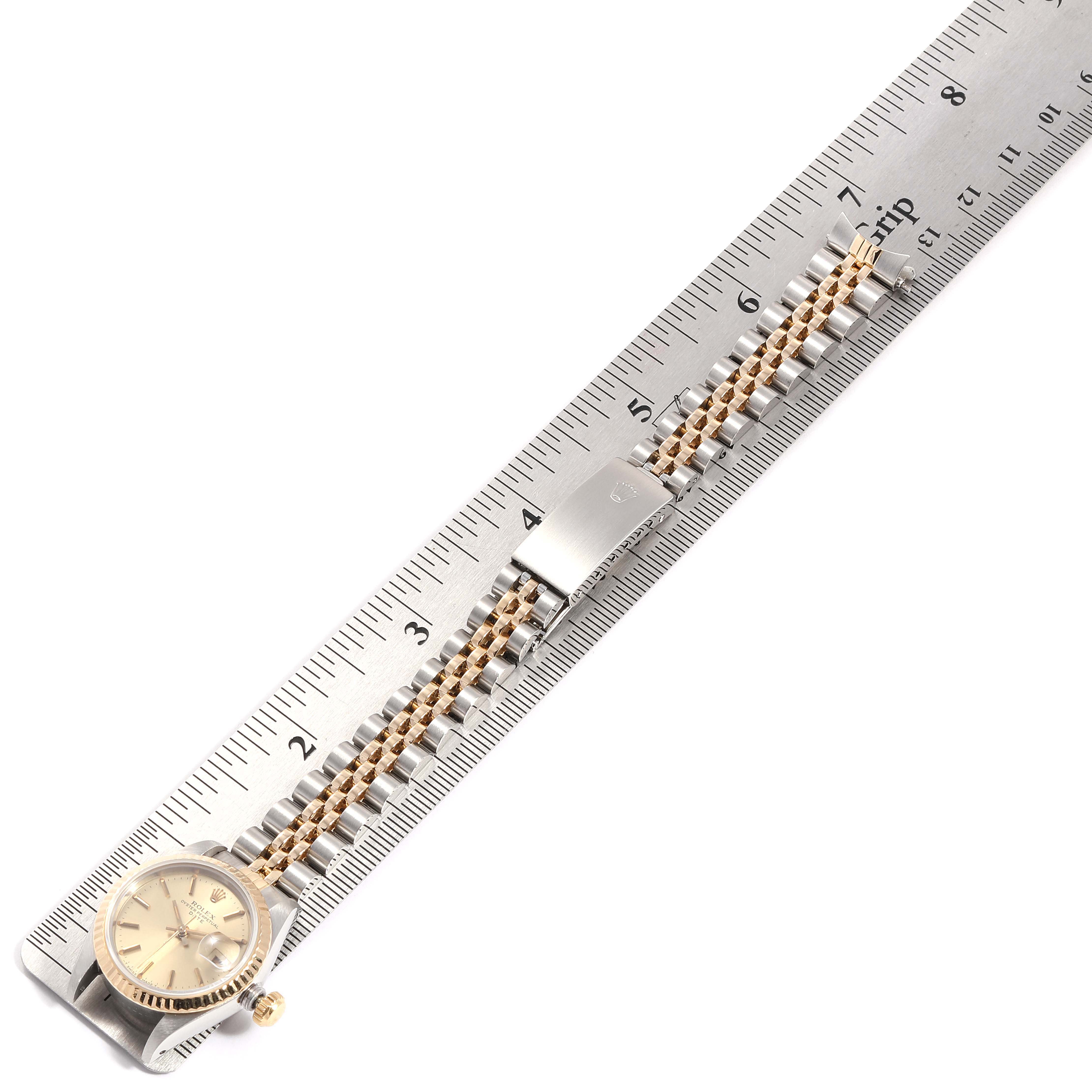 This Datejust model by Rolex is shown from above, displaying the face, bezel, bracelet, and clasp alongside a ruler for size reference.