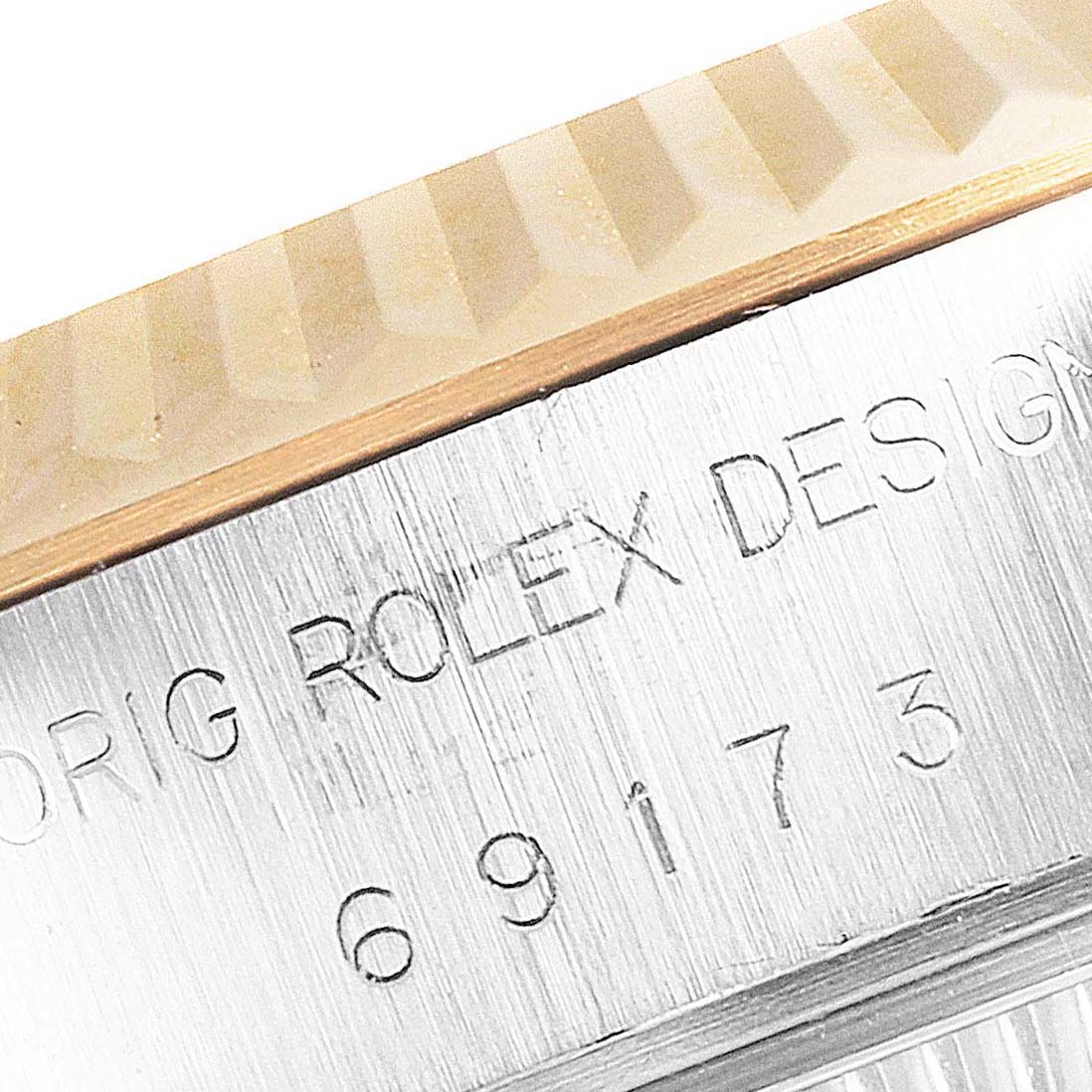 This close-up angle shows the fluted bezel and engraved design number of a Rolex Datejust 69173 Women's Steel and Gold (two tone) Blue Dial 69173 Women's Steel and Gold (two tone) Blue Dial watch.