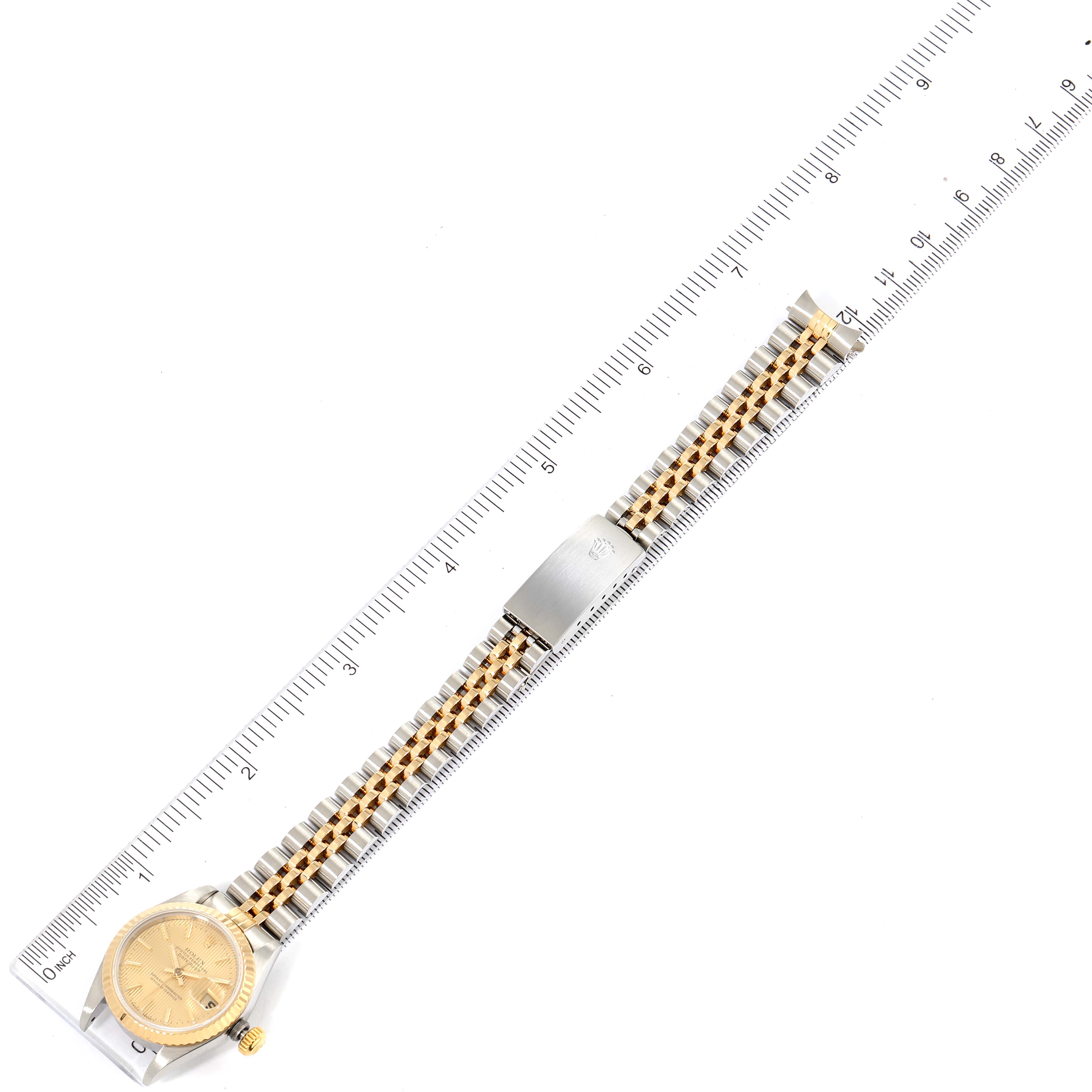 The image shows a Rolex Datejust 69173 Women's Steel and Gold (two tone) Champagne Dial 69173 Women's Steel and Gold (two tone) Champagne Dial watch laid flat with its bracelet extended and a ruler for scale.