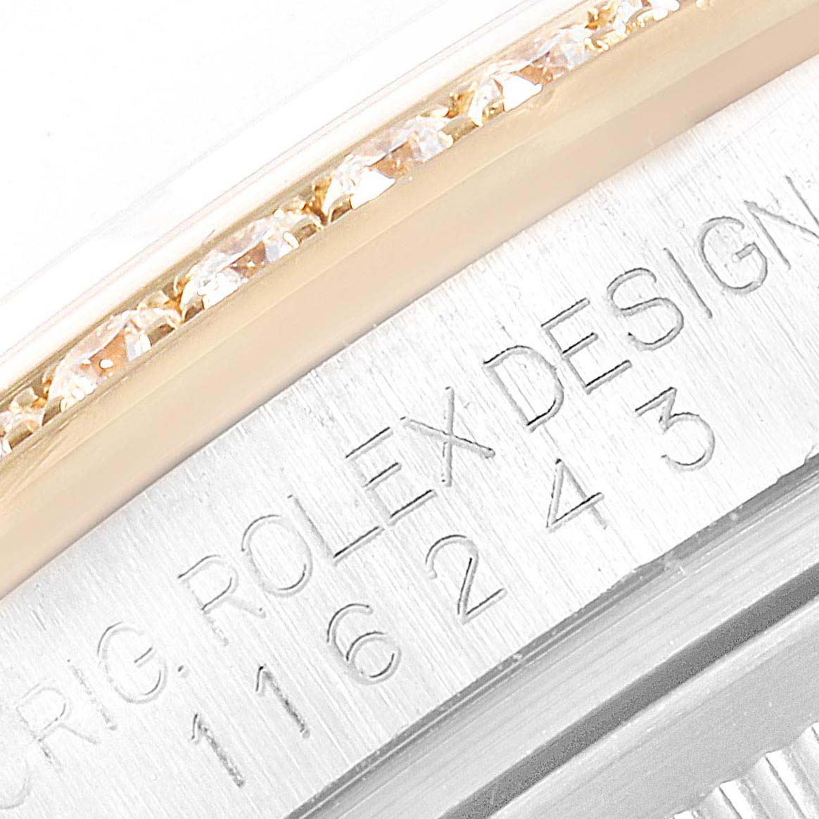 This image shows a close-up of the bezel and serial number engraving on a Rolex Datejust 116243 Men's Steel and Gold (two tone) White Dial 116243 Men's Steel and Gold (two tone) White Dial watch.