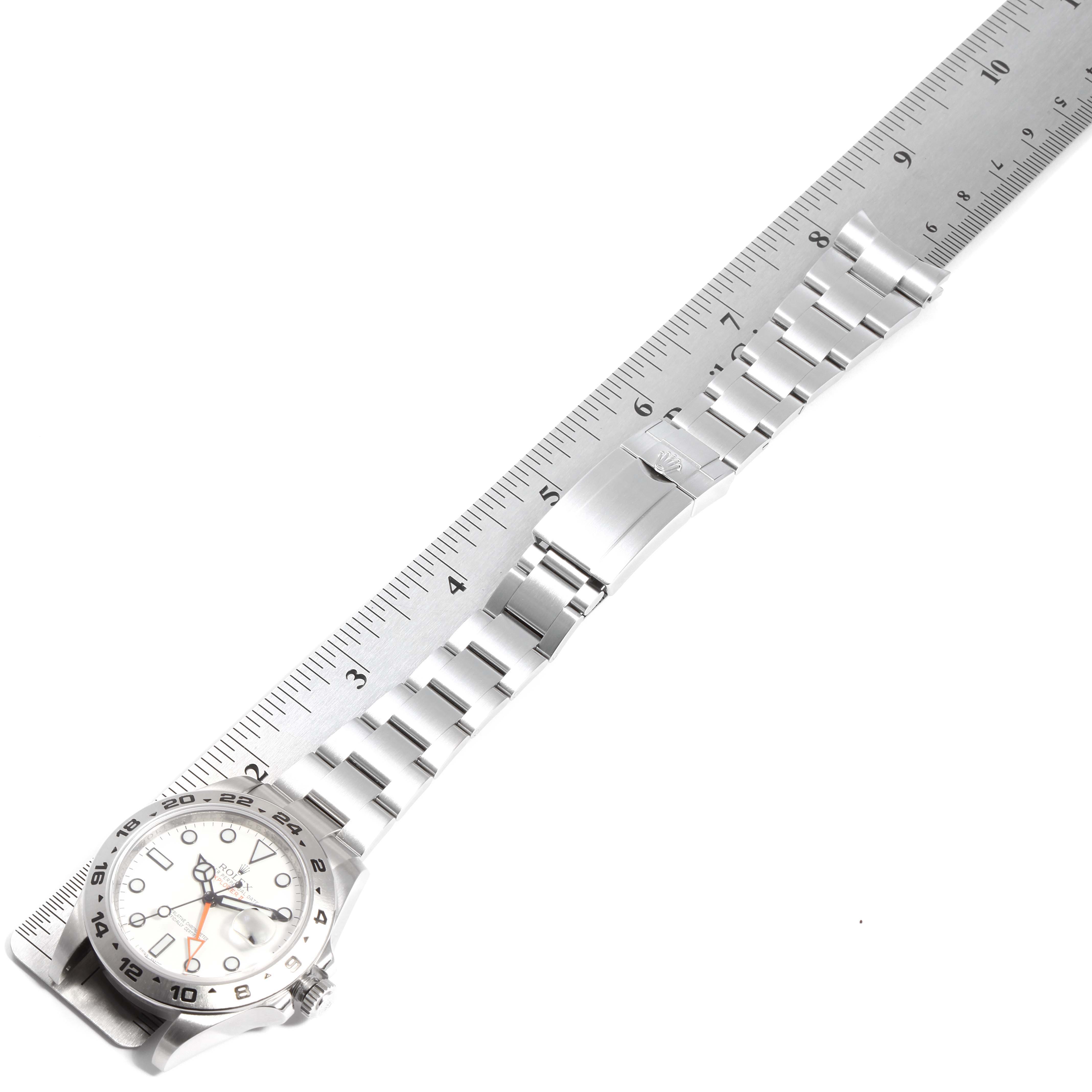 The image shows a Rolex Explorer 216570 Men
s Stainless Steel White Dial 216570 Men
s Stainless Steel White Dial watch laid flat with its bracelet alongside a ruler for measurement.