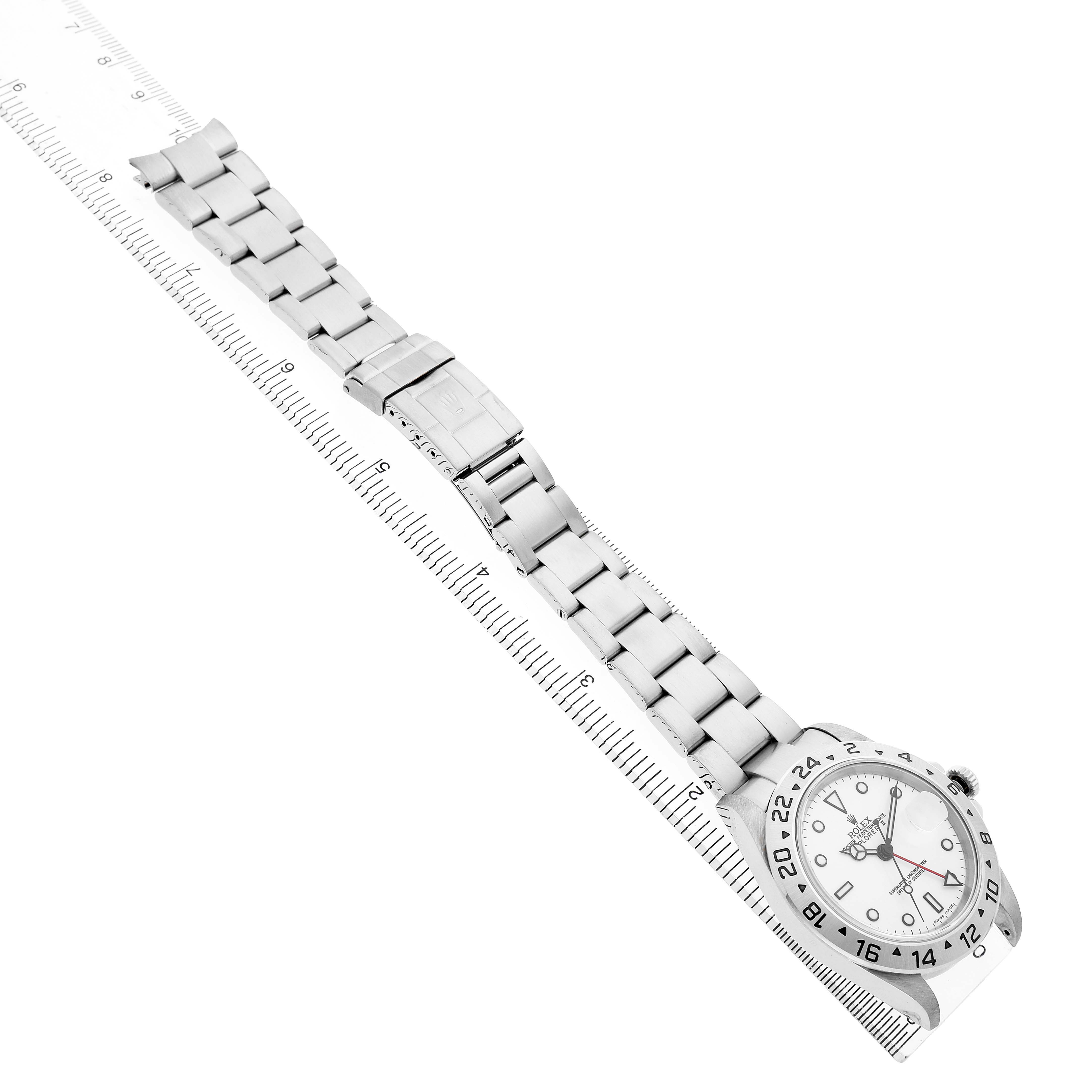 The image shows a Rolex Explorer 16570 Men's Stainless Steel White Dial watch laid flat, displaying the face and full metal bracelet alongside a ruler.