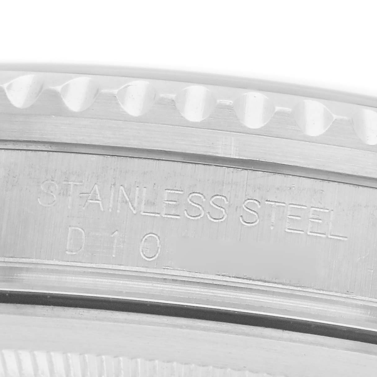 The image shows a close-up of the bezel and engraved markings on the case side of a Rolex GMT-Master model 16710, indicating "Stainless Steel D10."