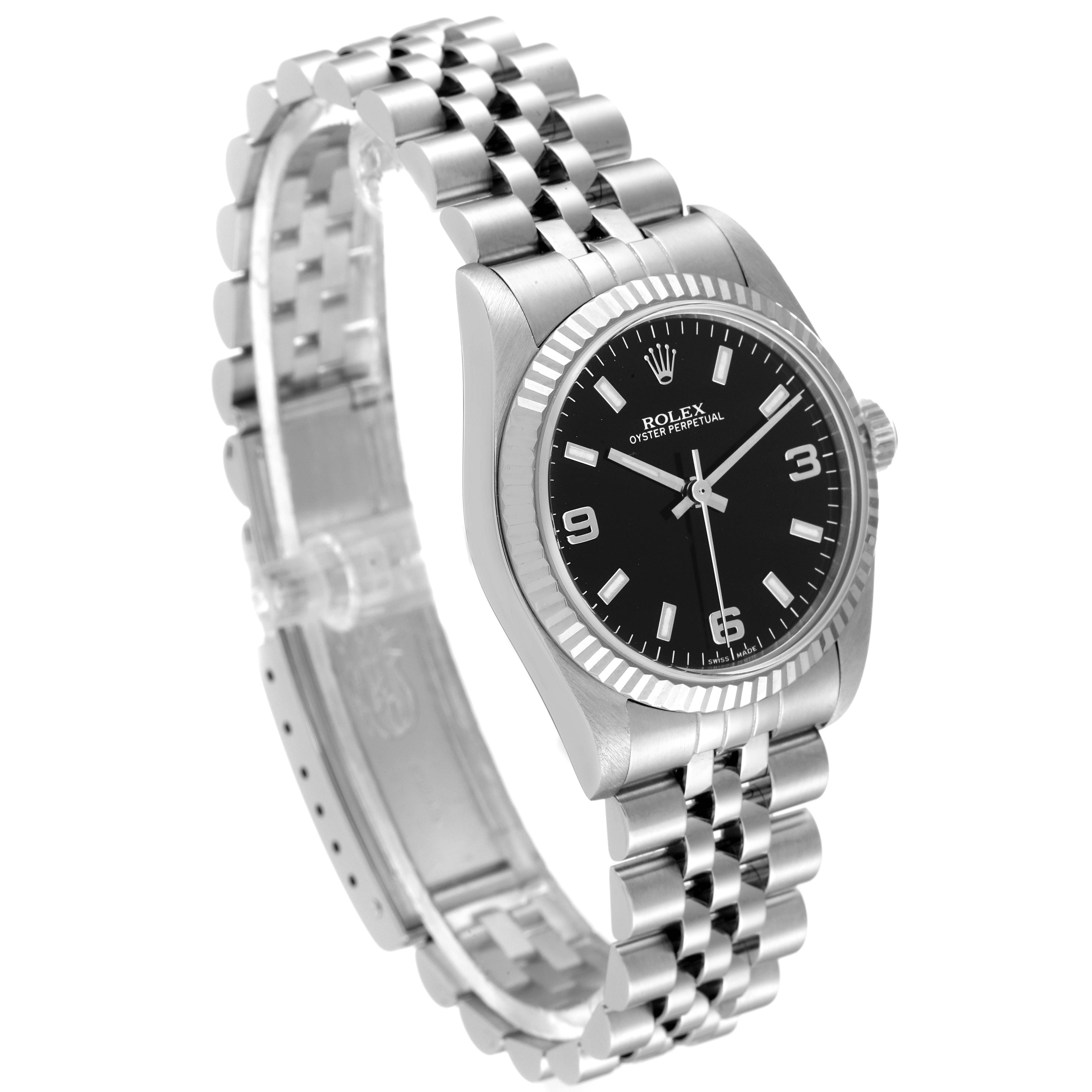 The image shows a Rolex Mid-Size 77014 Women's Stainless Steel Black Dial 77014 Women's Stainless Steel Black Dial Oyster Perpetual watch at an angled view, highlighting its black dial, bezel, and Jubilee bracelet.