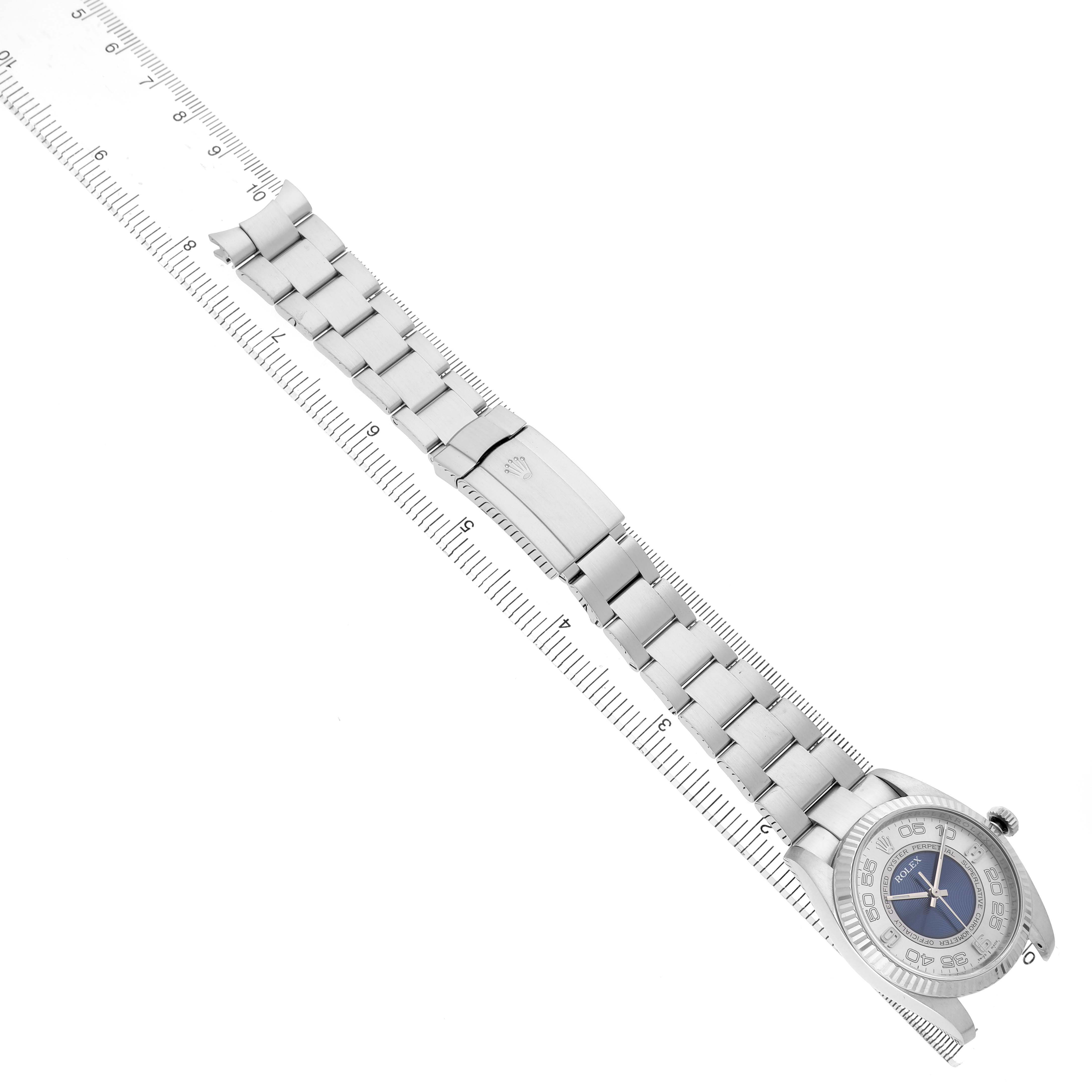 The Rolex Oyster Perpetual 116034 Men's Stainless Steel Blue Dial is shown from a top-down angle, displaying the full bracelet, clasp, and watch face alongside a ruler for scale.