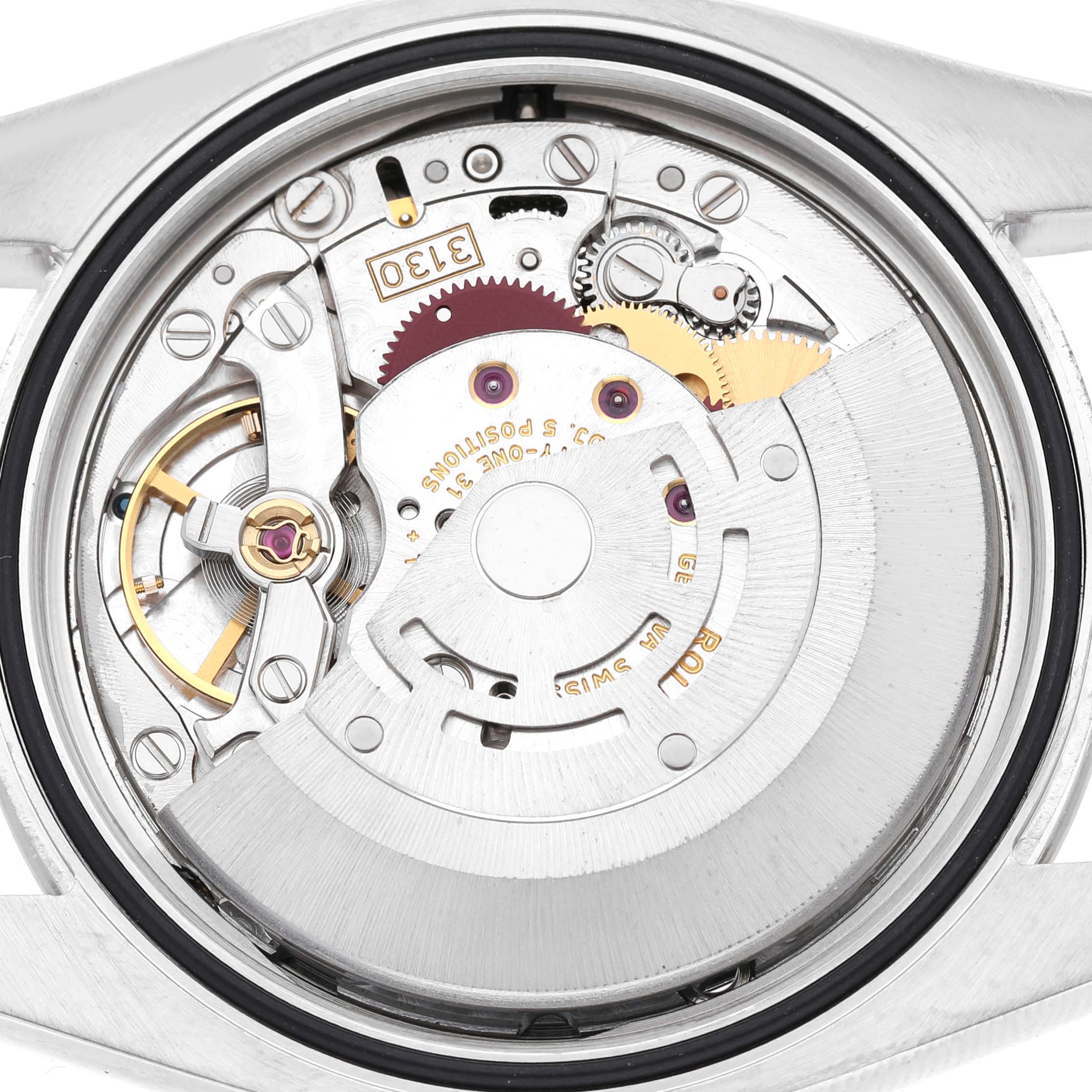 The image shows a close-up of the movement inside a Rolex Oyster Perpetual 116034 Men's Stainless Steel Blue Dial watch, focusing on its intricate internal mechanics.