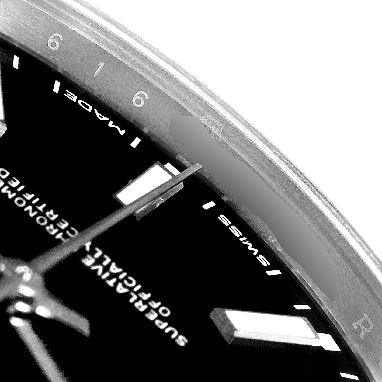 This close-up of a Rolex Oyster Perpetual 114300 Men's Stainless Steel Black Dial 114300 Men's Stainless Steel Black Dial watch shows part of the dial, markers, and hands, along with "Swiss Made" text.