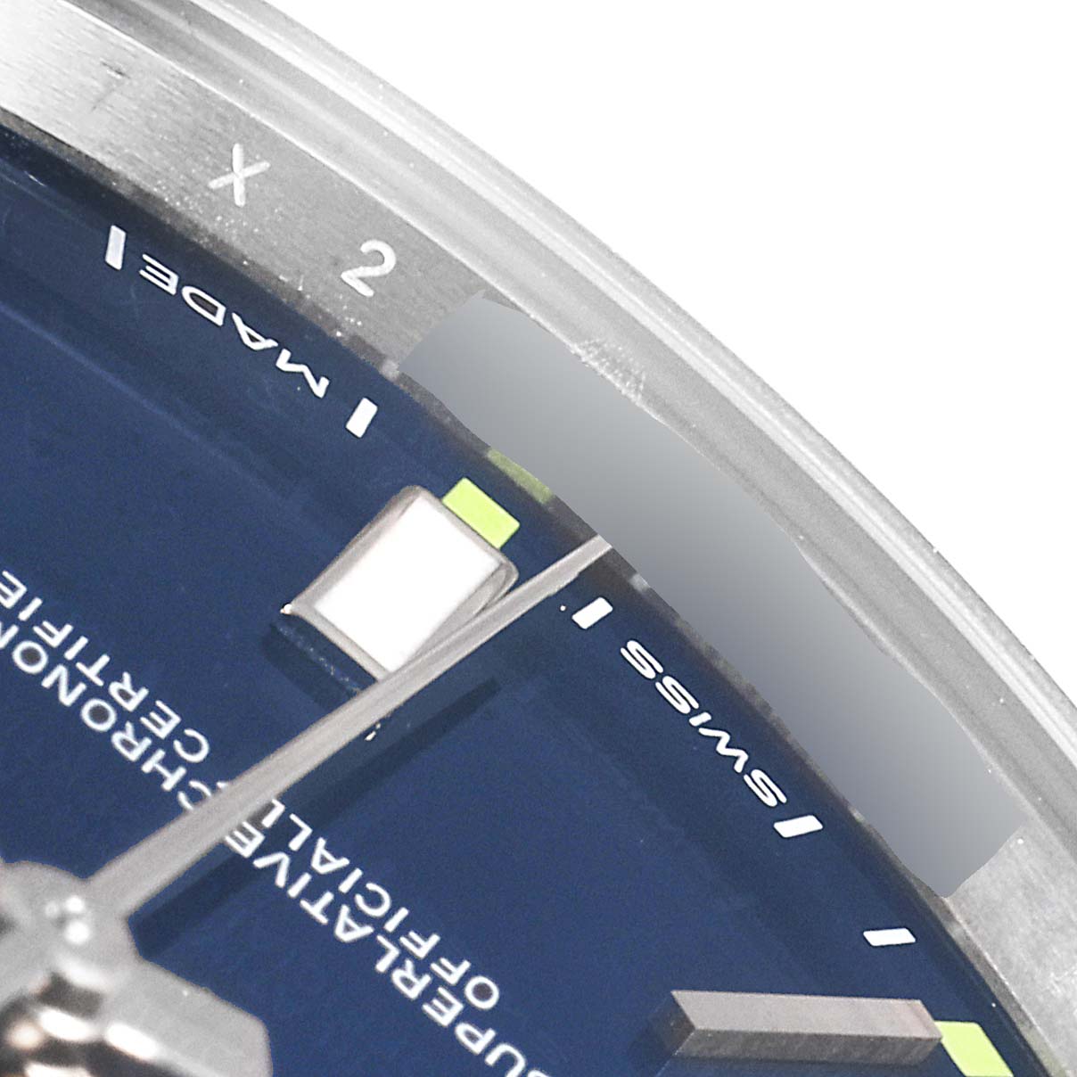 The image shows a close-up of the dial and part of the hands of a Rolex Oyster Perpetual 114300 Men's Stainless Steel Blue Dial 114300 Men's Stainless Steel Blue Dial watch, focusing on the "Swiss Made" text.
