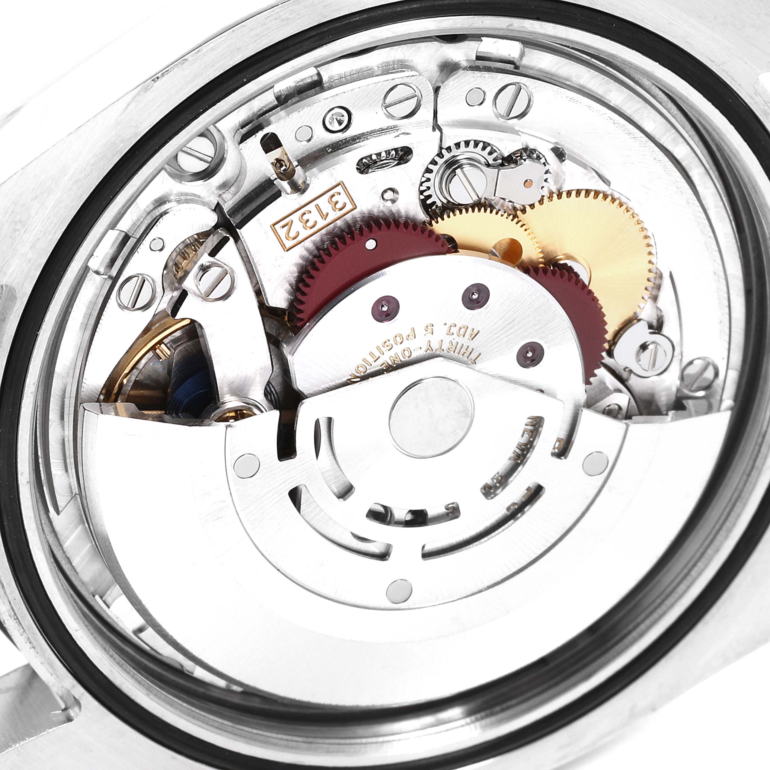 The image shows the internal mechanism of the Rolex Oyster Perpetual 114300 Men's Stainless Steel Blue Dial 114300 Men's Stainless Steel Blue Dial watch from a close-up angle, highlighting the gears and movement.