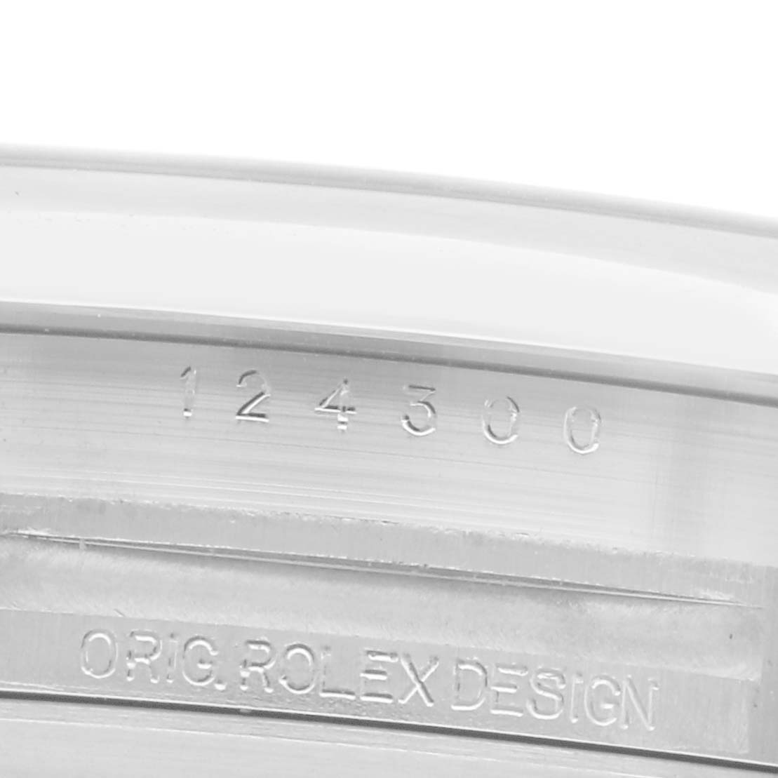 The image shows a close-up of the Rolex Oyster Perpetual model 124300, focusing on the engraved model number and "ORIG. ROLEX DESIGN" on the case edge.