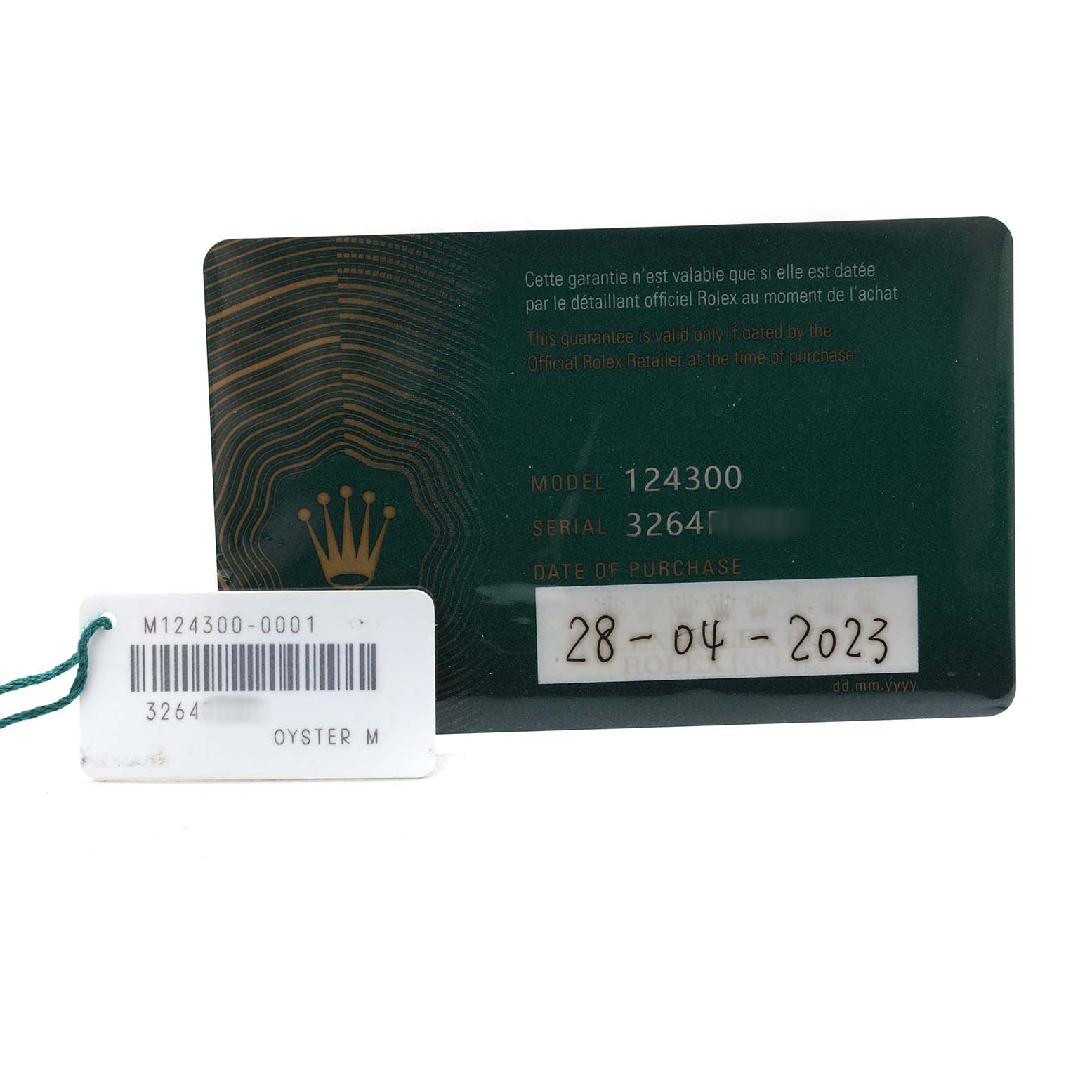 The image shows a warranty card and a tag for the Rolex Oyster Perpetual 124300 Men's Stainless Steel Silver Dial model, displayed from a frontal angle.