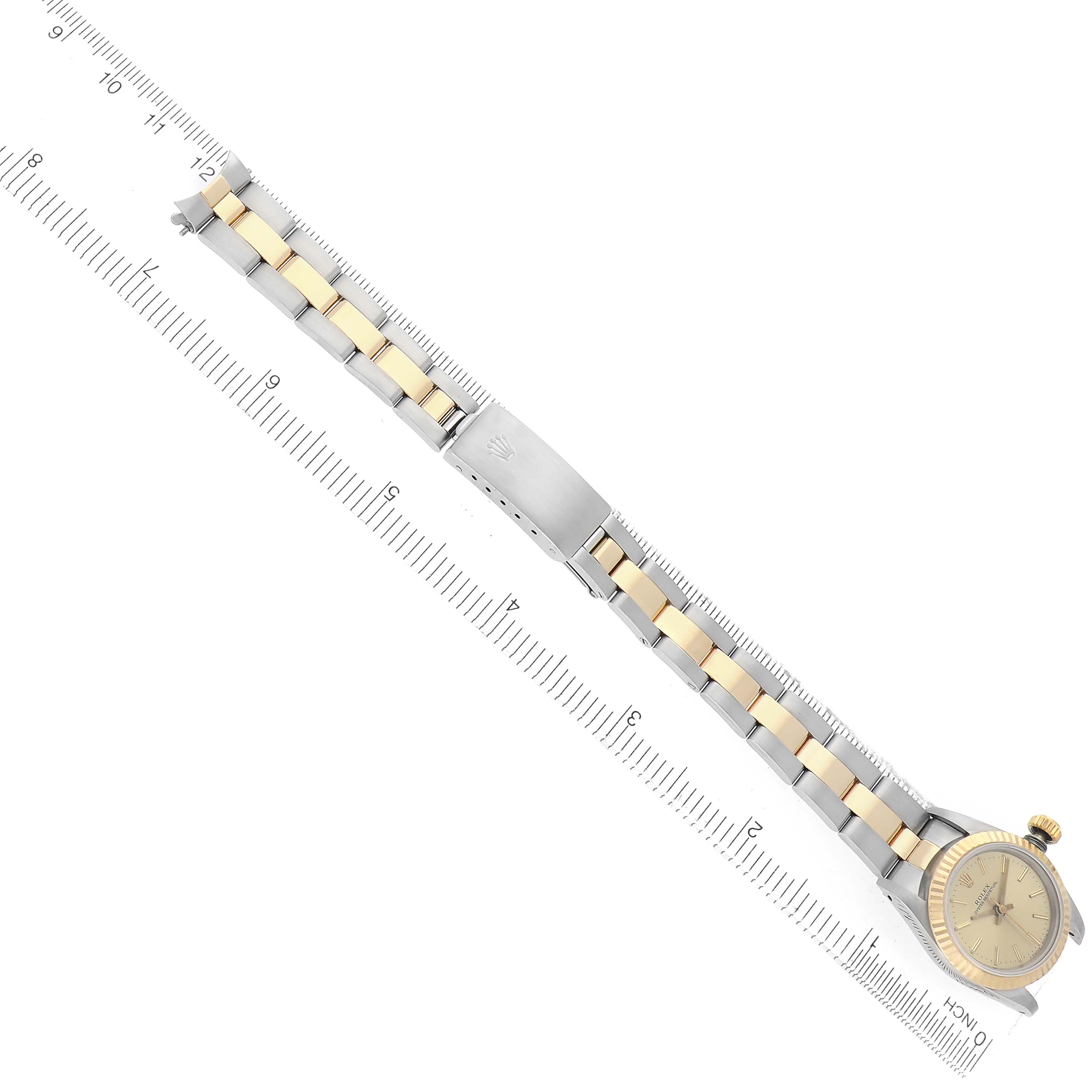 The image shows a Rolex Oyster Perpetual model 67193 men's watch from a top angle, displaying the full bracelet, clasp, and face, aligned diagonally with a ruler.