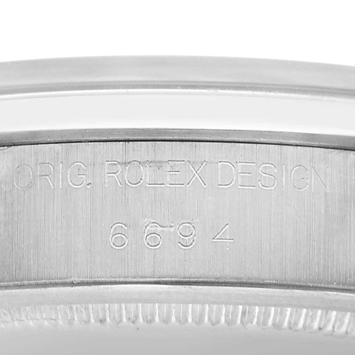 The image shows the engraved side of the case with the model number of a Rolex Date 6694 Men's Stainless Steel Silver Dial watch.