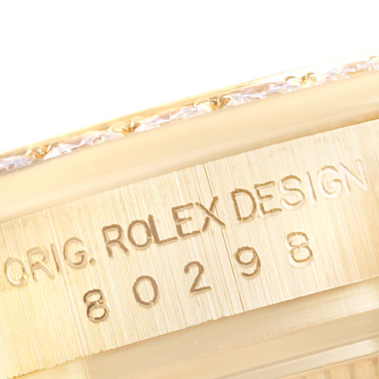 The image shows a close-up of the engraved serial number and bezel of the Rolex Pearlmaster 80298 Women
s Yellow Gold Mother of Pearl Dial 80298 Women
s Yellow Gold Mother of Pearl Dial watch, showcasing its detailed craftsmanship.