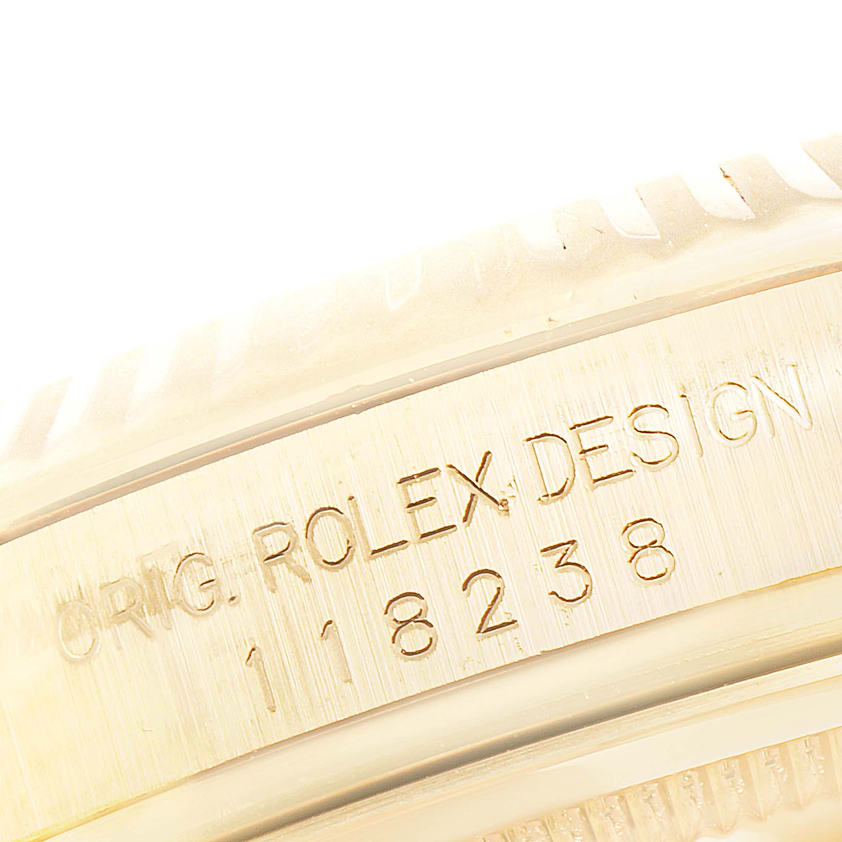 This image shows a close-up of the engraved bezel and case side of a Rolex President 118238 Men's Yellow Gold Blue Dial 118238 Men's Yellow Gold Blue Dial model watch.