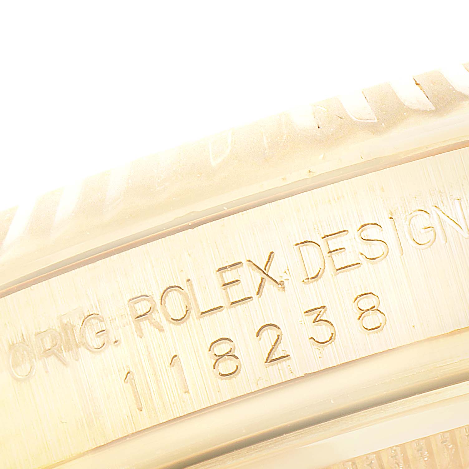 The image shows a close-up of the Rolex President 118238 Men
s Yellow Gold Silver Dial 118238 Men
s Yellow Gold Silver Dial model, highlighting the engraved serial number and brand name on the case.