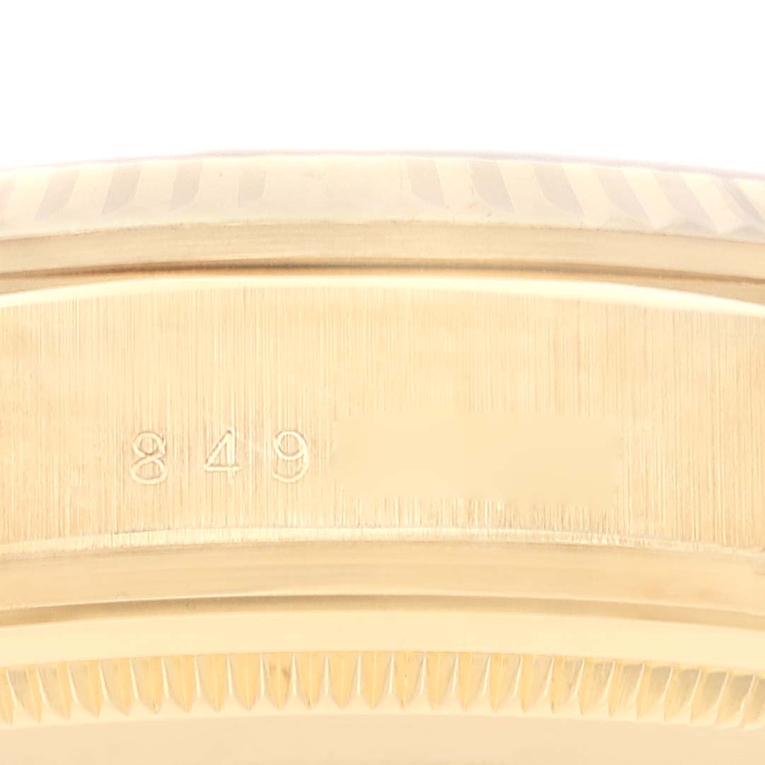 The image shows a close-up view of the side of a Rolex President 18038 Men
s Yellow Gold Champagne Dial 18038 Men
s Yellow Gold Champagne Dial watch, featuring part of the bezel and case with engraved markings.