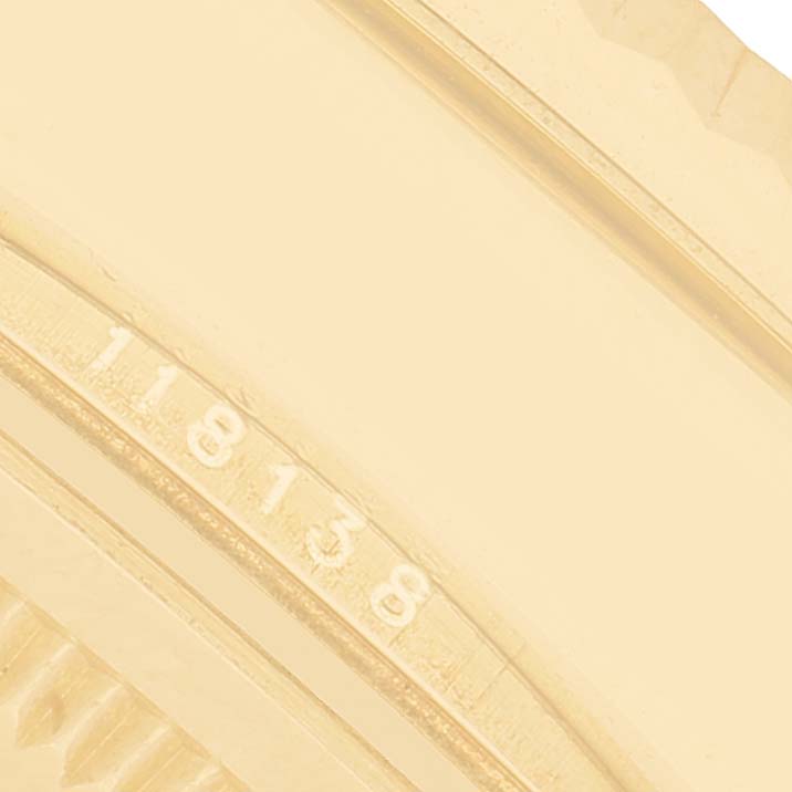 The image shows a close-up of the case with engravings on a Rolex President 118138 Men's Yellow Gold Orange Dial model, showcasing part of its bezel.