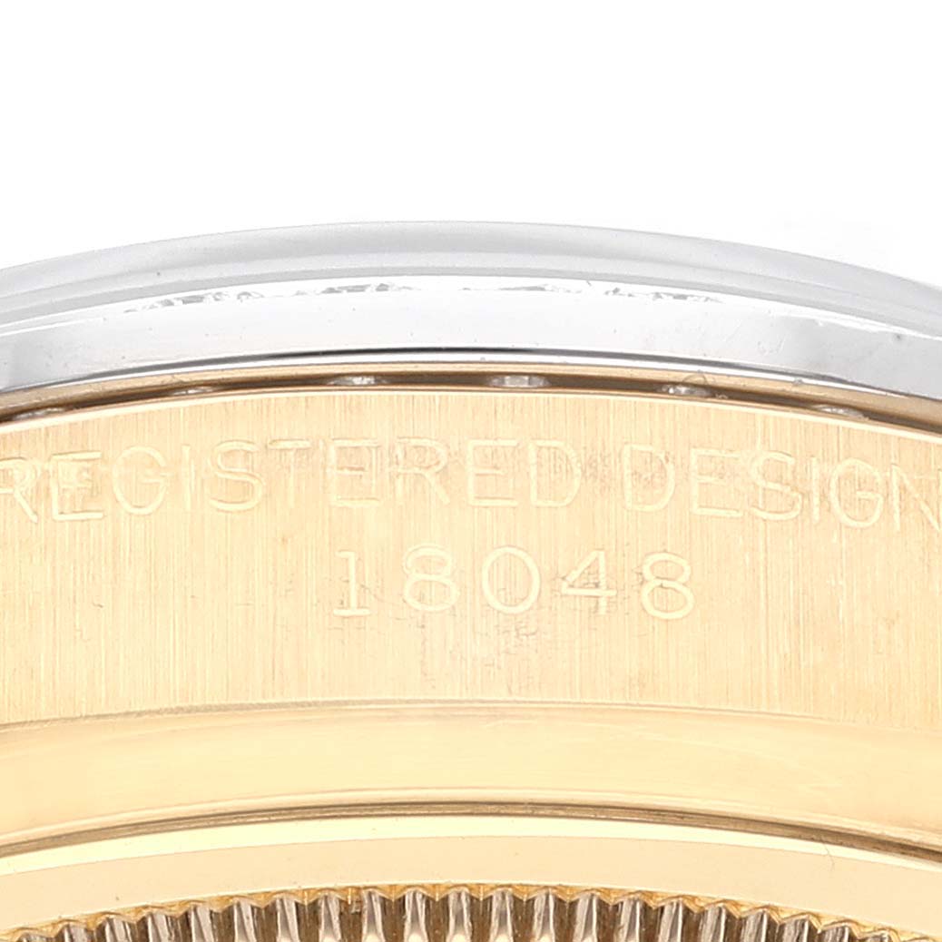 The image shows a close-up of the side of a Rolex President 18048 Men's Yellow Gold Champagne Dial 18048 Men's Yellow Gold Champagne Dial model watch, focusing on its serial engraving.