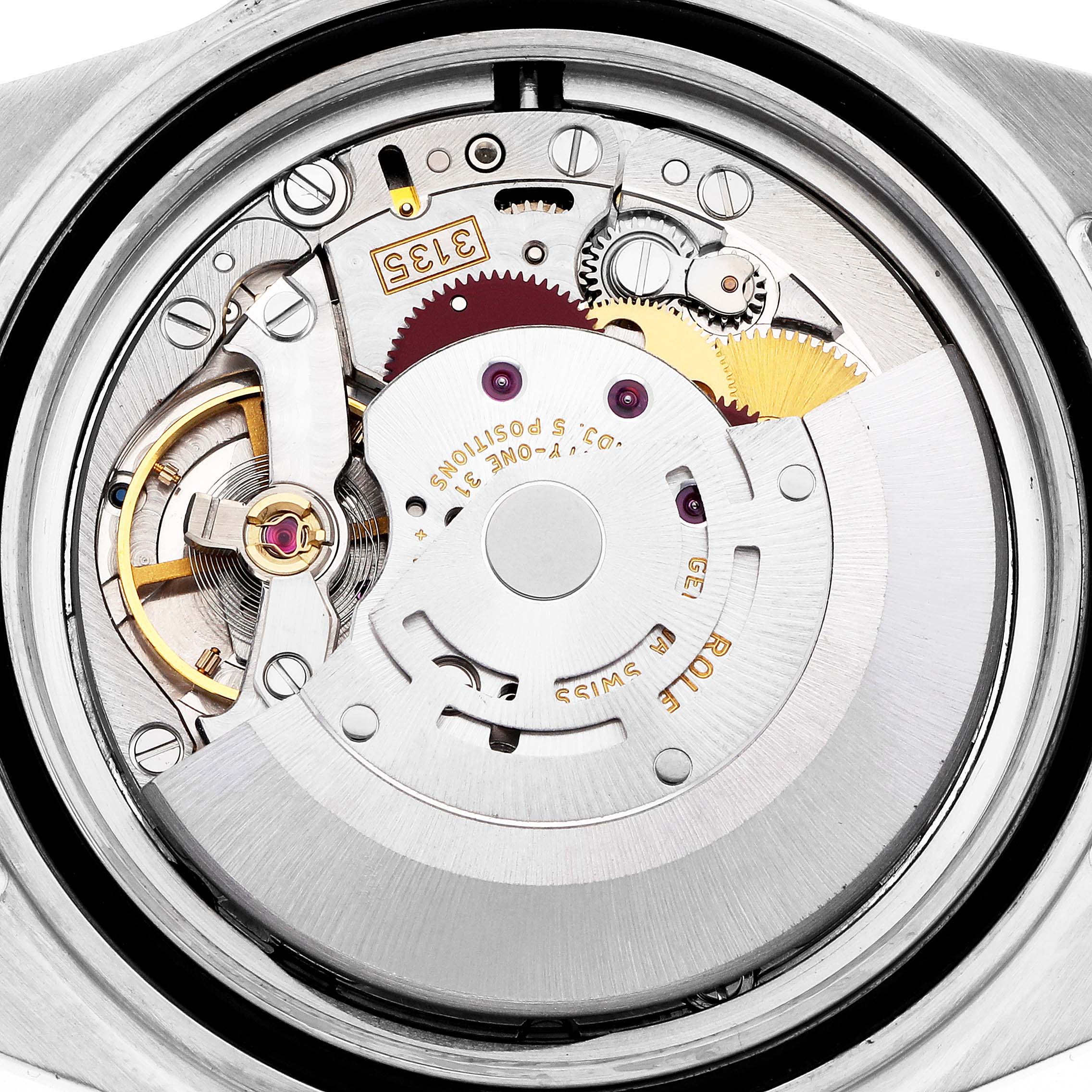 The image shows the movement of a Rolex Submariner model 16610, focusing on its intricate gears, balance wheel, and rotor, viewed from the back.